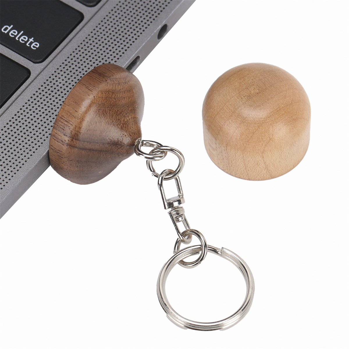 Holzschlüsselanhänger, die an einem Laptop befestigt sind. Einer ist befestigt, einer ist separat.