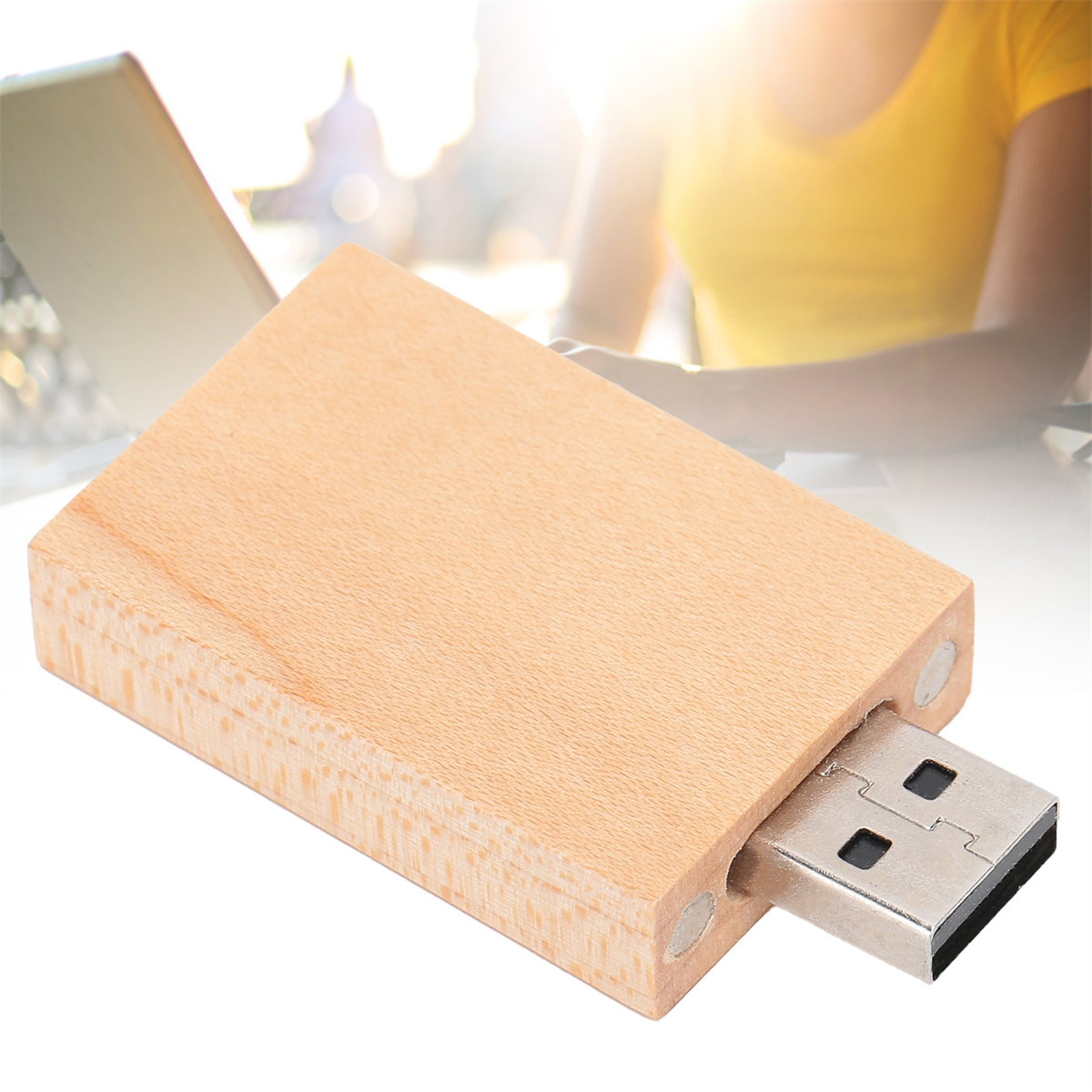 USB-Stick aus Holz mit metallischem USB-Anschluss, auf Holzoberfläche.
