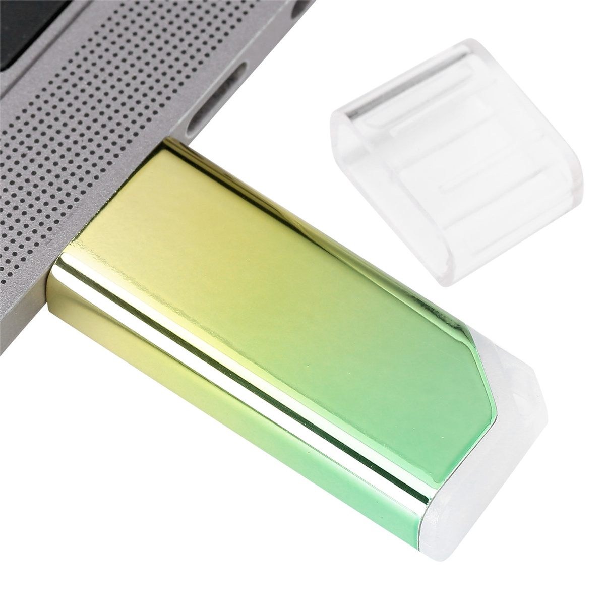 Ein gold-grüner USB-Stick steckt in einem Laptop. Eine transparente Kappe liegt rechts.