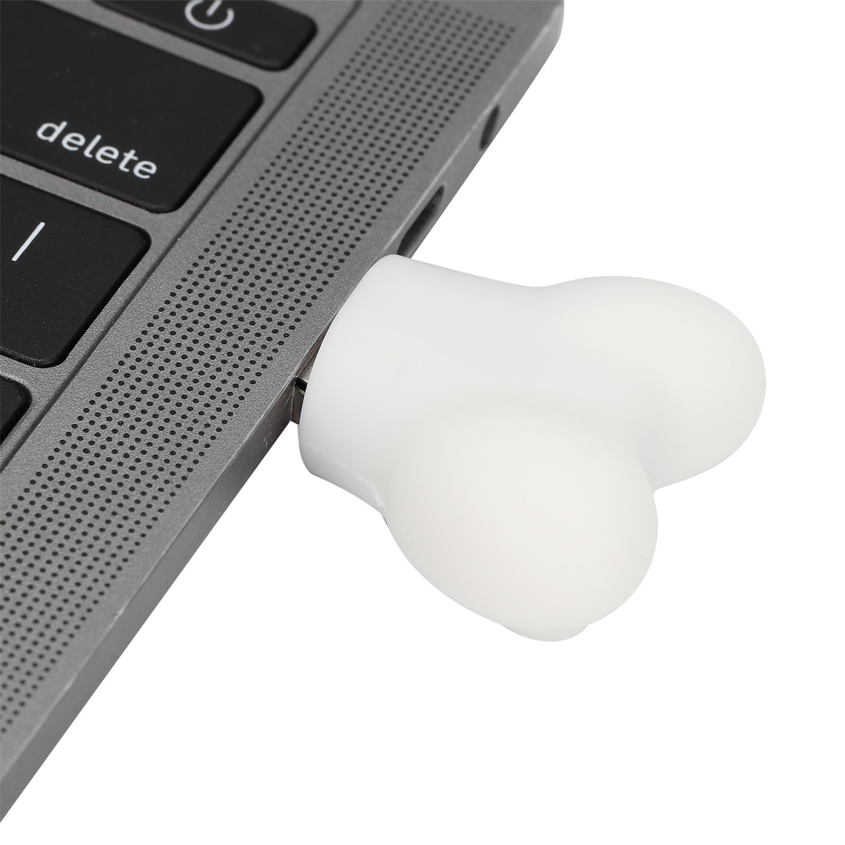 Weißer USB-Stick in Knochenform, in einen Laptop gesteckt. Der Stick ist rechts.