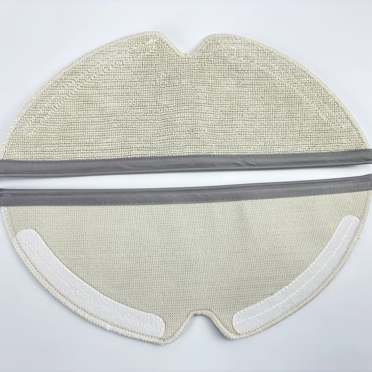 Nakładka do mopa odkurzacza automatycznego na białej powierzchni.