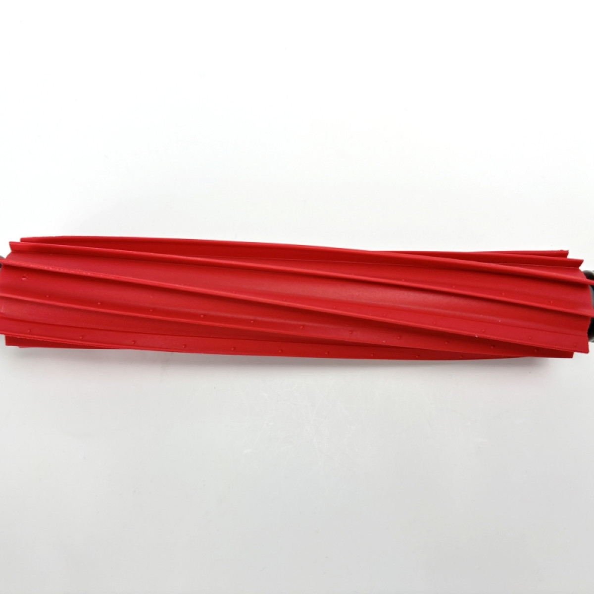 Czerwony wałek do odkurzacza z wieloma równoległymi rowkami, na białym tle.