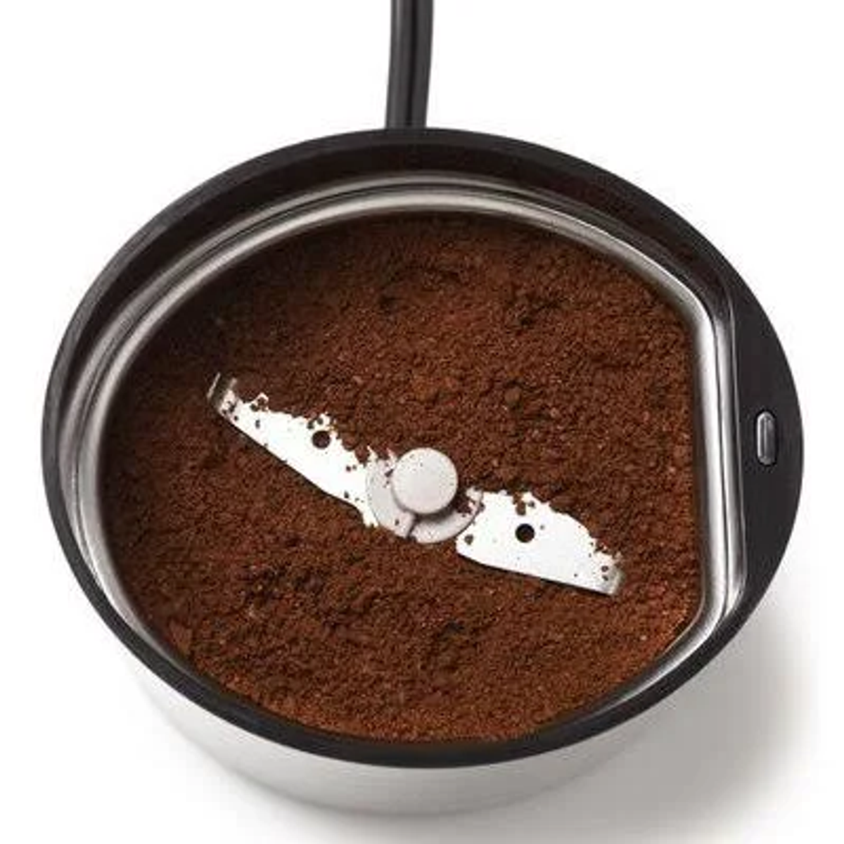 Młynek do kawy z zmieloną kawą w środku. Czarny i srebrny. Białe tło.