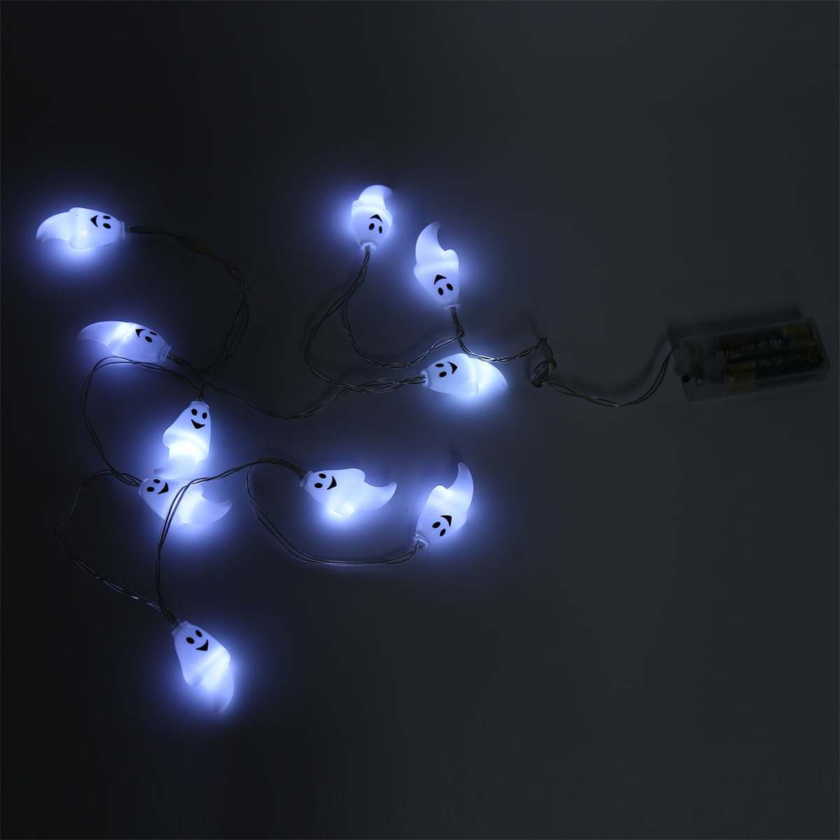 Kette aus leuchtenden, weißen, geisterförmigen Lichtern auf dunklem Hintergrund.