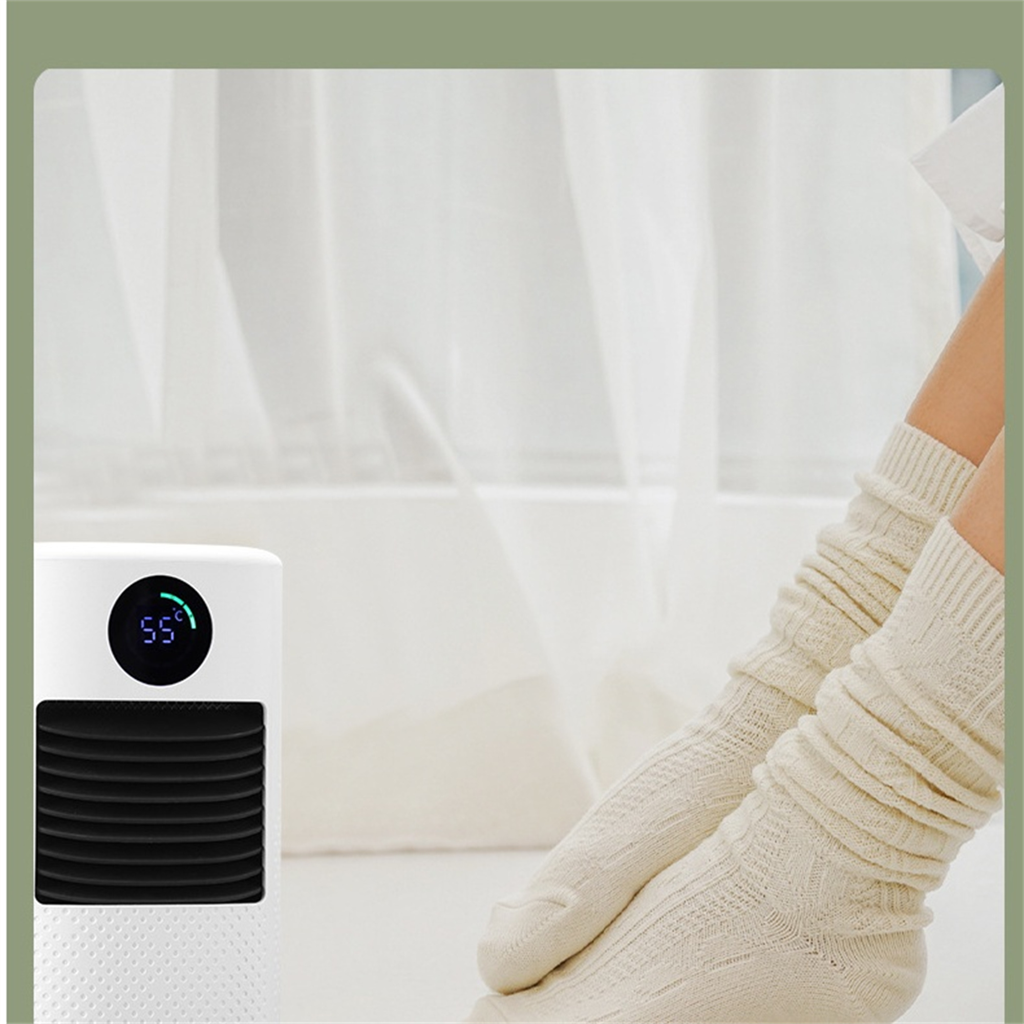 Ein weißer Heizlüfter und Beine in cremefarbenen Socken, in der Nähe eines Fensters mit transparenten Vorhängen.