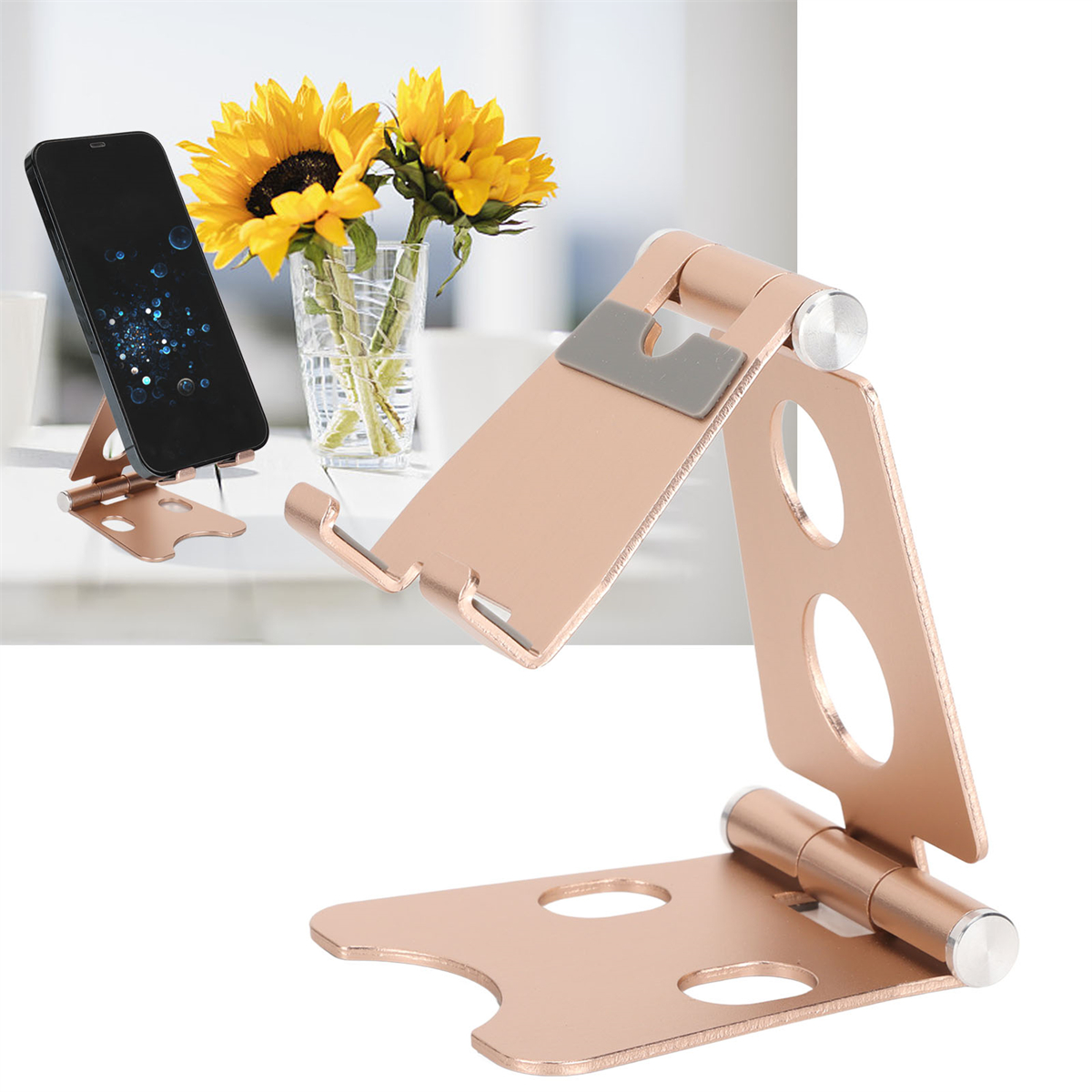 Roségoldener Telefonständer mit Telefon und Sonnenblumen in einer Vase, auf weißer Oberfläche.