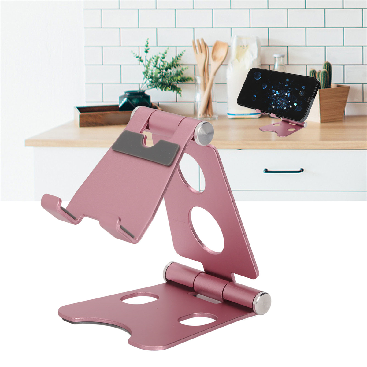 Rosa Telefonständer. Ein Telefon ruht darauf. Der Ständer ist offen und abgewinkelt. Küche im Hintergrund.
