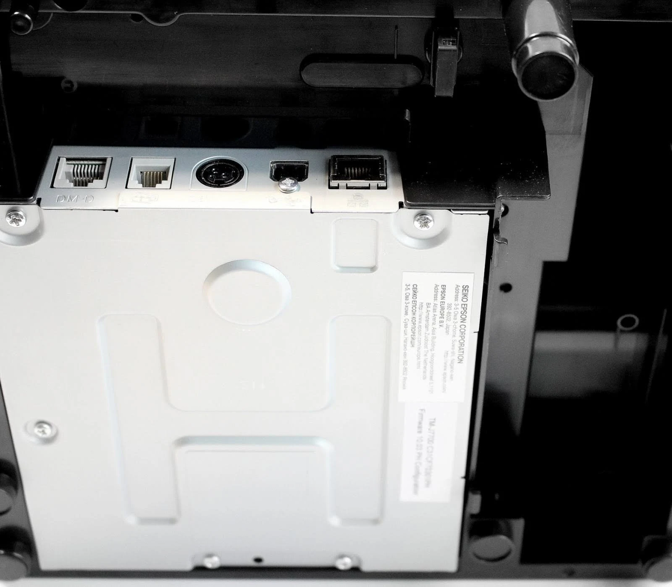Primo piano della parte posteriore di una stampante Epson. Ha porte e un'etichetta di servizio.