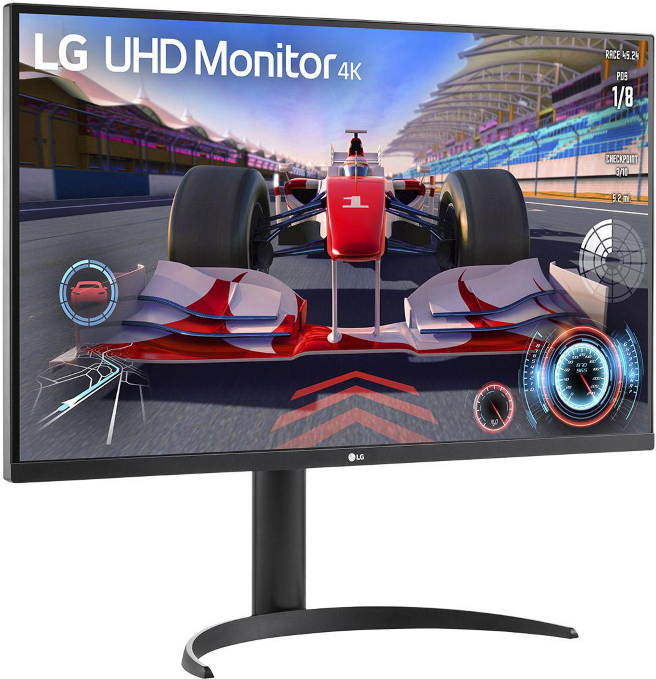 Monitor LG 4K mostrando un juego de carreras. El monitor tiene un soporte negro sobre un fondo blanco.