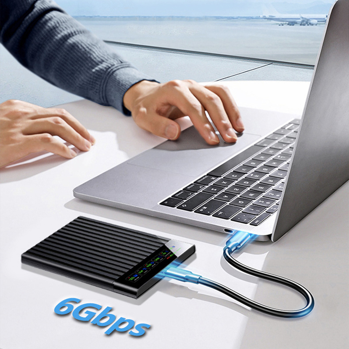 Laptop, der über ein blaues Kabel mit einer schwarzen externen Festplatte verbunden ist.