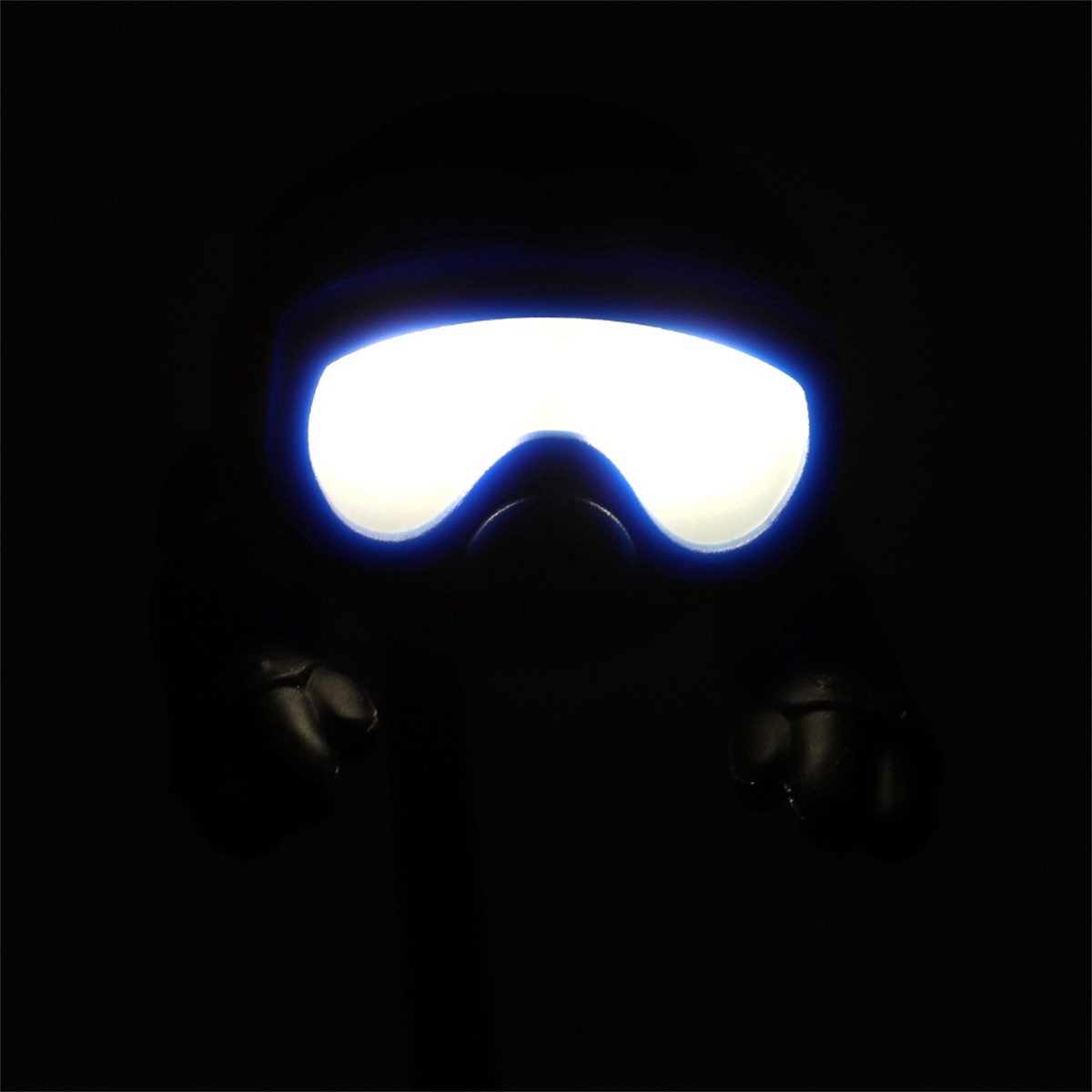 Eine schwarze Gesichtsmaske mit hellem weißem Licht, das aus den Augen kommt, und zwei schwarzen Handschuhen.