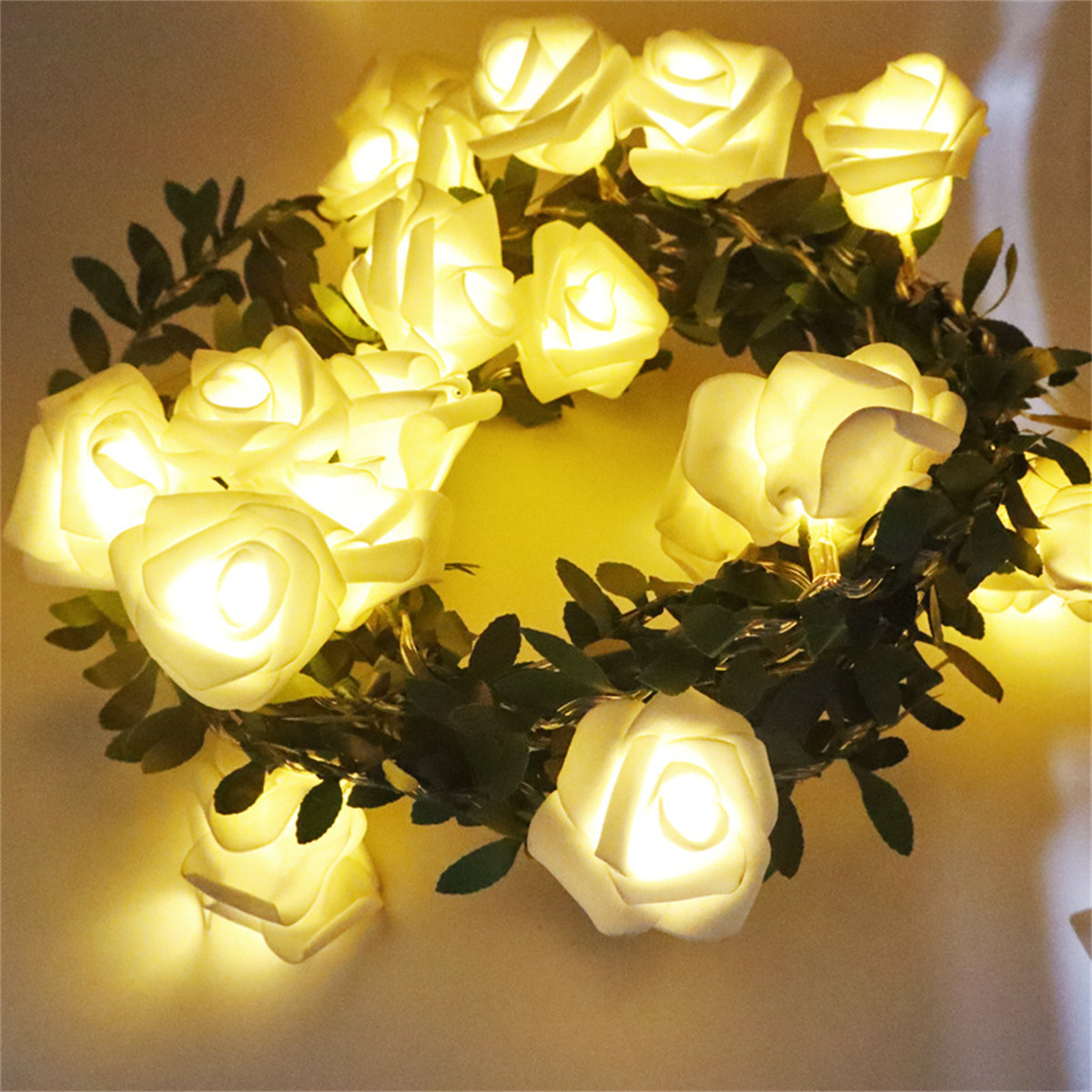 Ein kreisförmiger Kranz aus beleuchteten weißen rosenförmigen Lichtern.