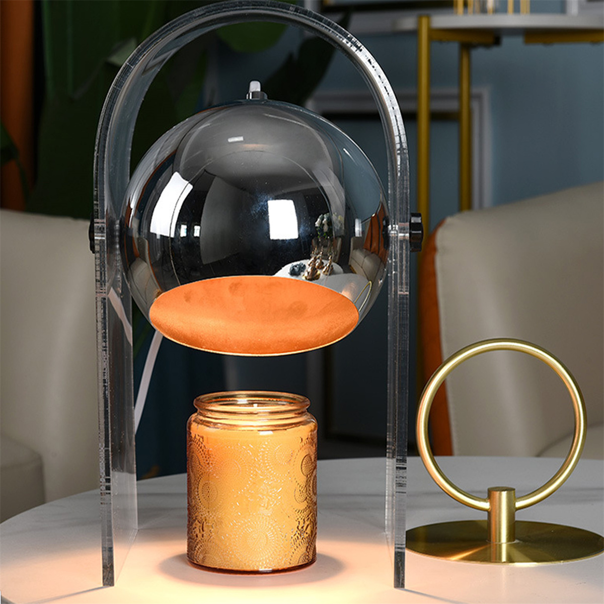 Eine moderne Lampe mit einer Glaskugel und einem orangefarbenen Sockel. Der Sockel steht auf einem weißen Tisch.