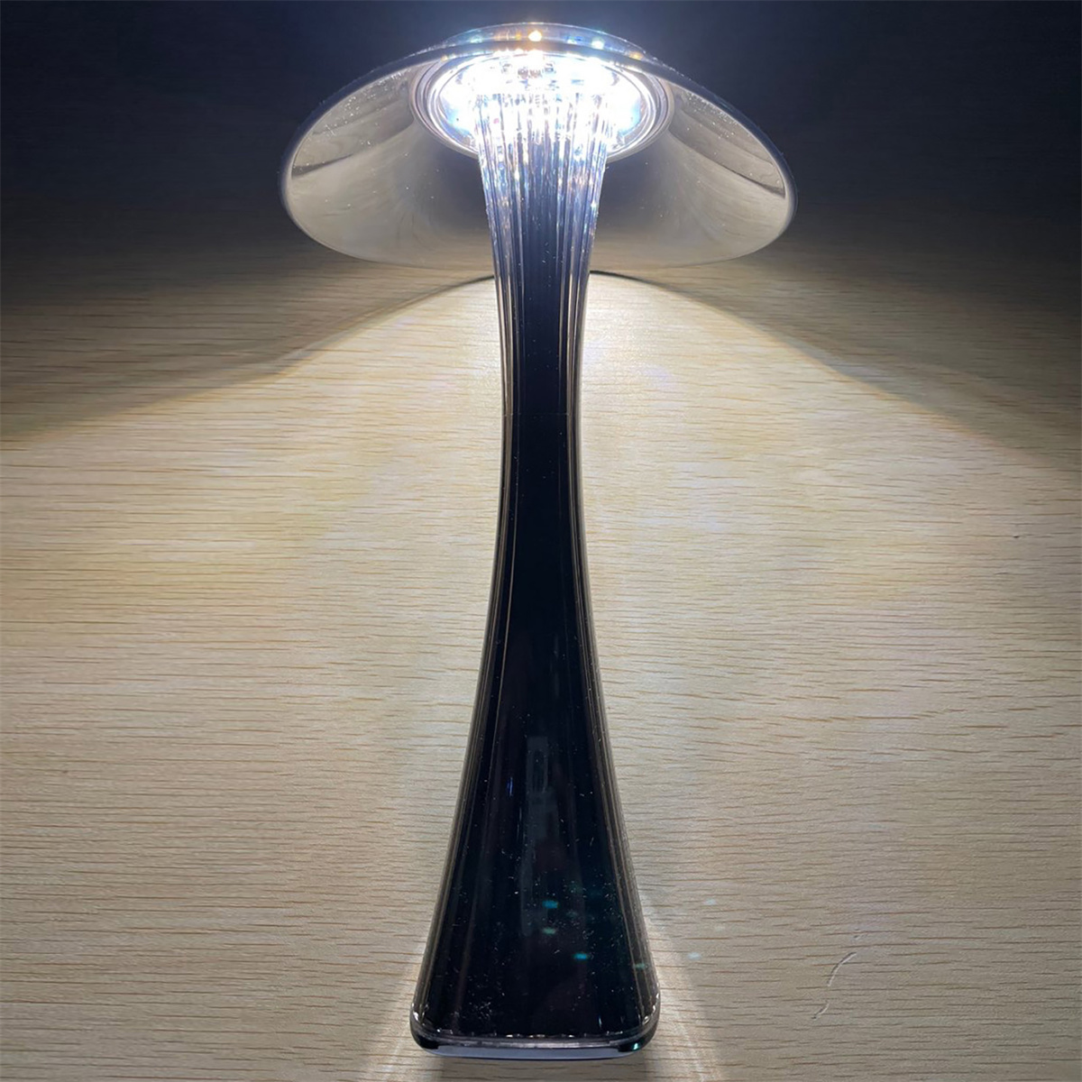 Eine moderne schwarz-silberne Schreibtischlampe. Sie hat ein schlankes Design und ist beleuchtet.