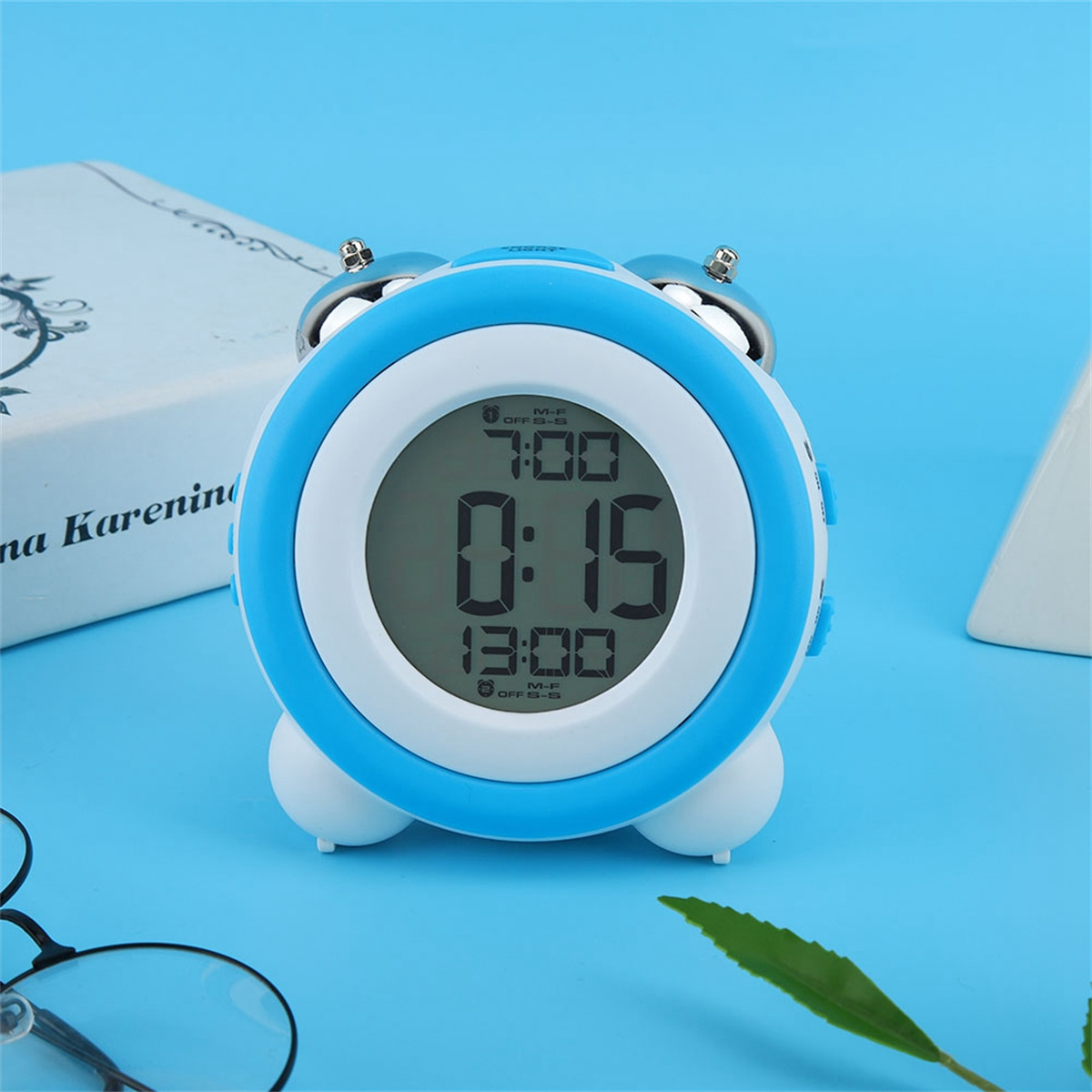 Blauer und weißer digitaler Wecker. Das Display zeigt die Uhrzeit und das Datum an. Der Hintergrund ist blau.
