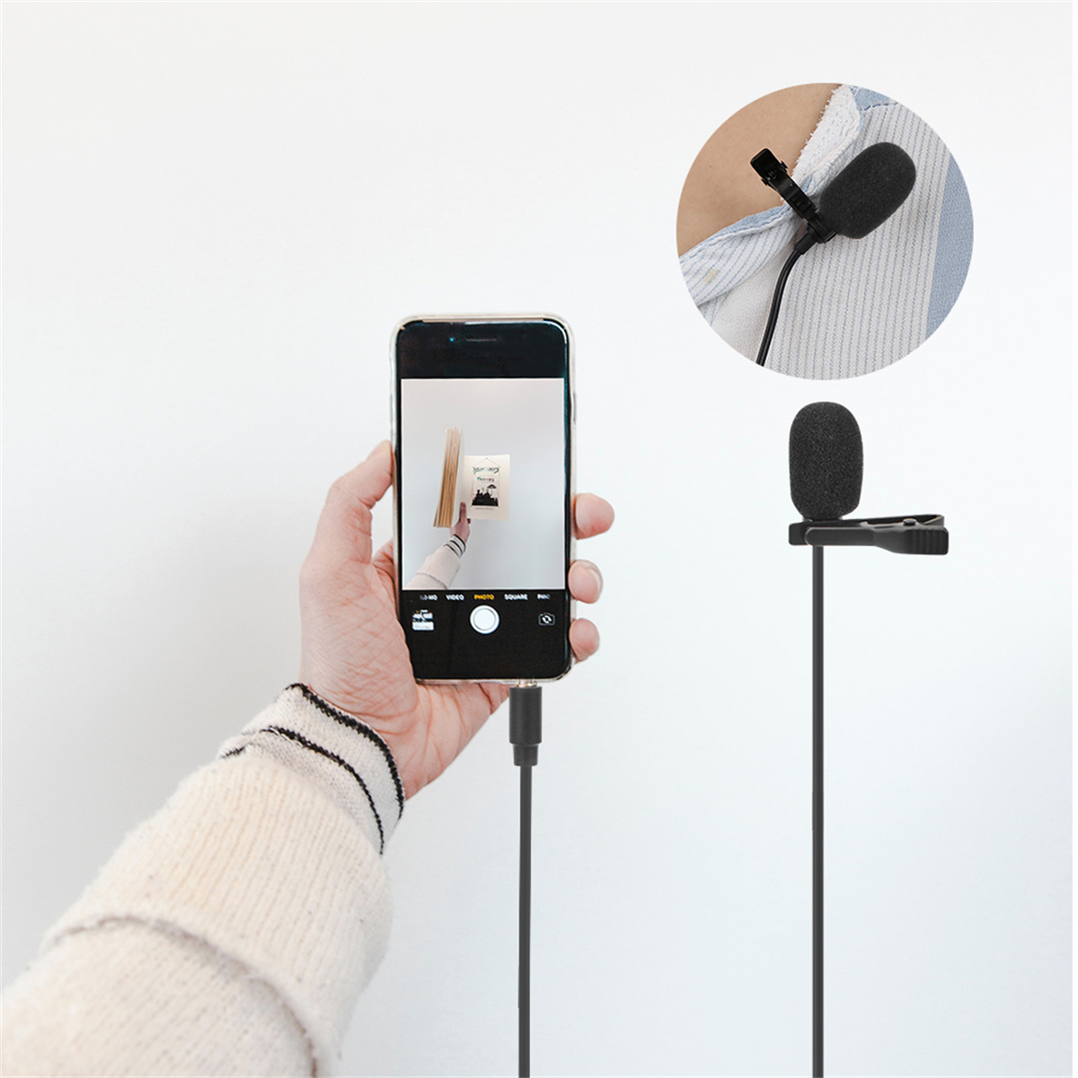 Eine Person hält ein Telefon und macht ein Foto mit einem Mikrofon, das an einem Hemd befestigt ist.