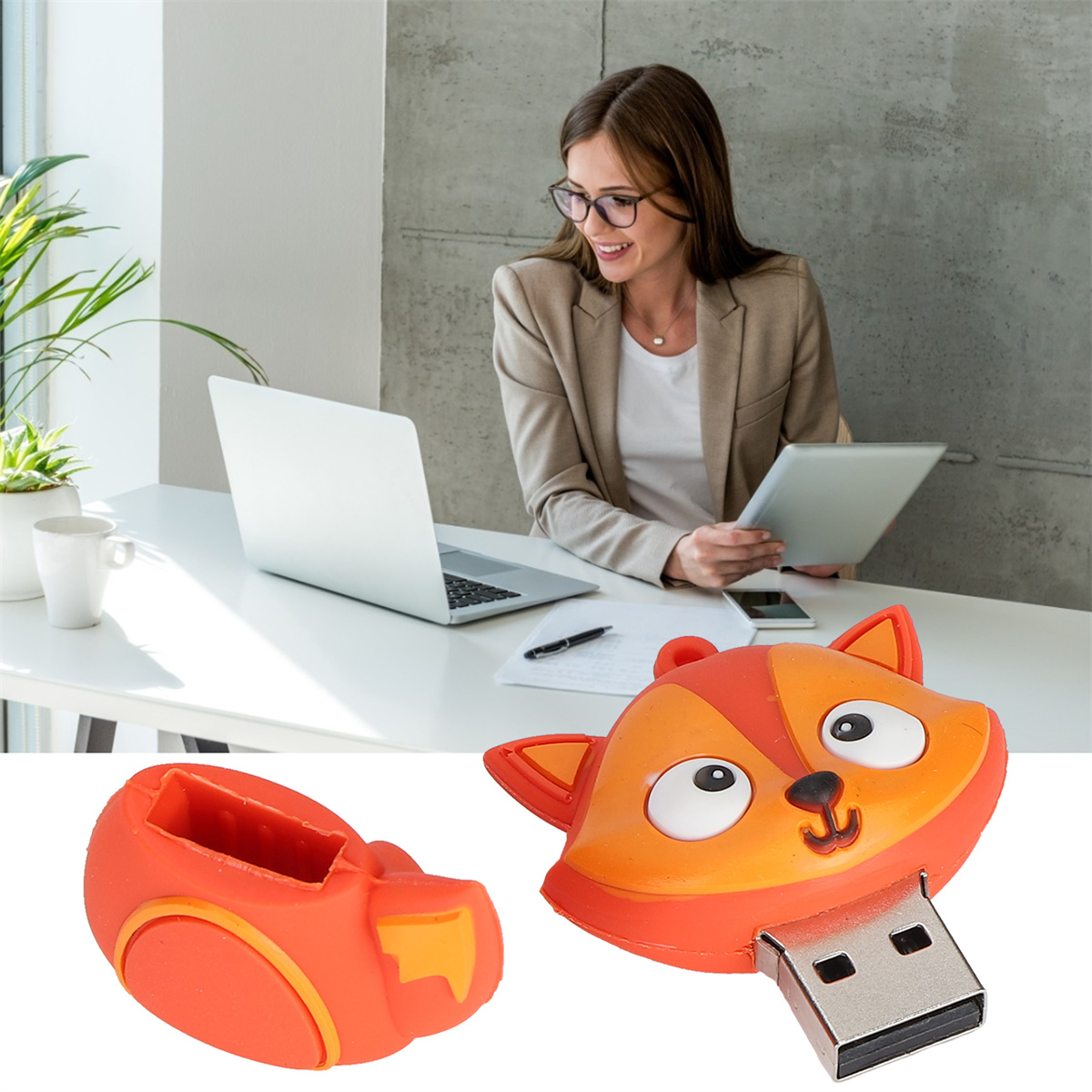 Ein fuchsformiger USB-Stick, orange, mit einer Frau, die im Hintergrund einen Laptop benutzt.