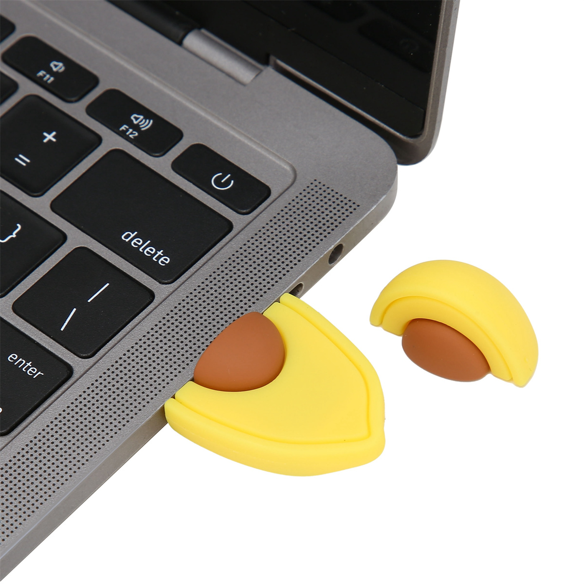 Ein gelber USB-Stick in Avocadoform, der an einen Laptop angeschlossen ist.