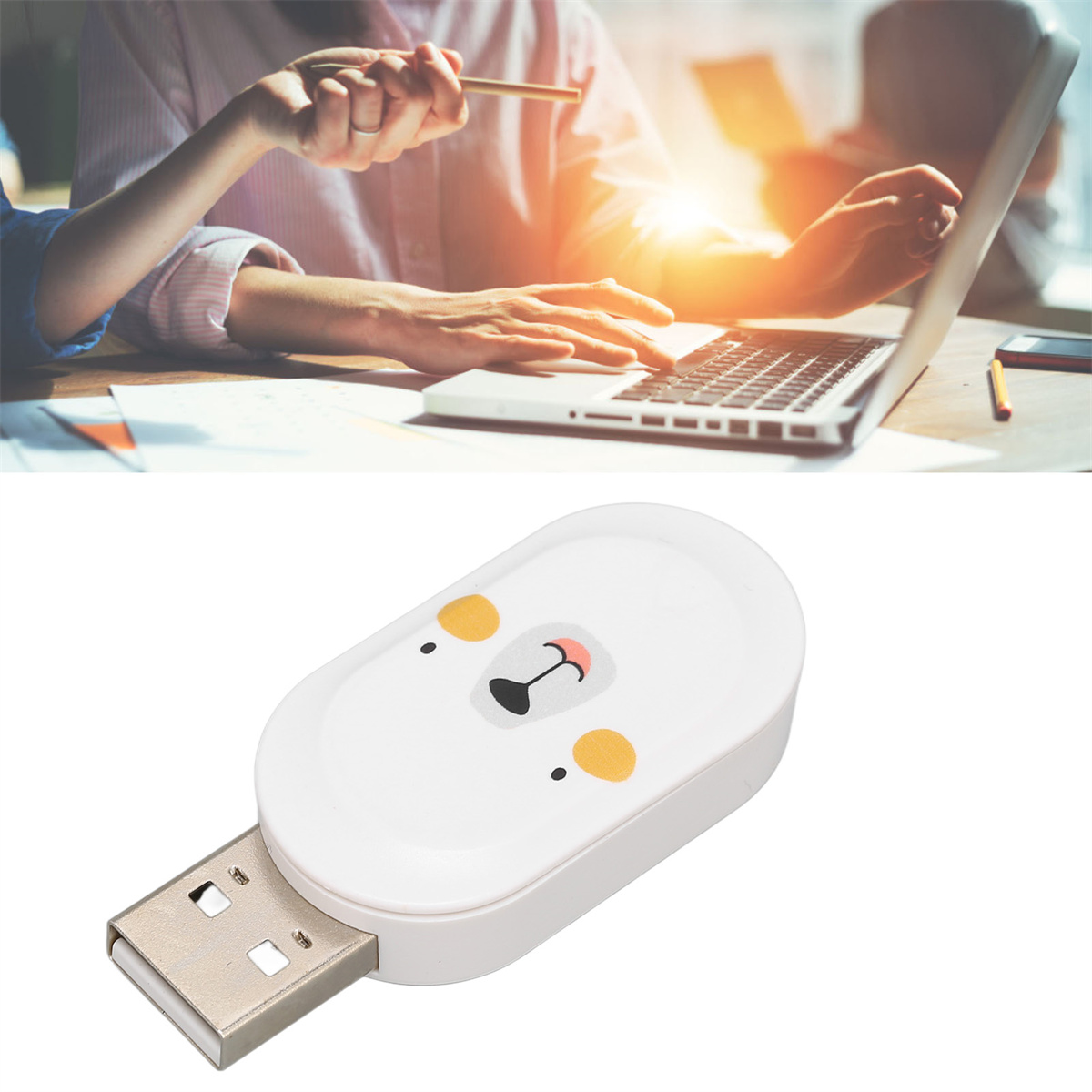 Ein weißer USB-Stick mit einem Bärengesicht auf der Vorderseite. Ein Laptop und eine Person im Hintergrund.