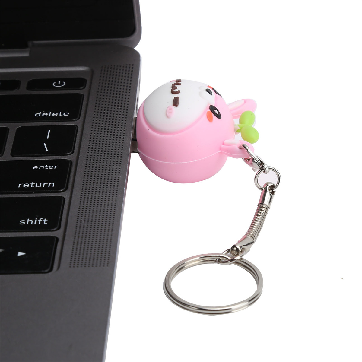 Ein rosa Hasen-USB-Laufwerk, das an einen Laptop angeschlossen ist. Der Laptop ist grau.
