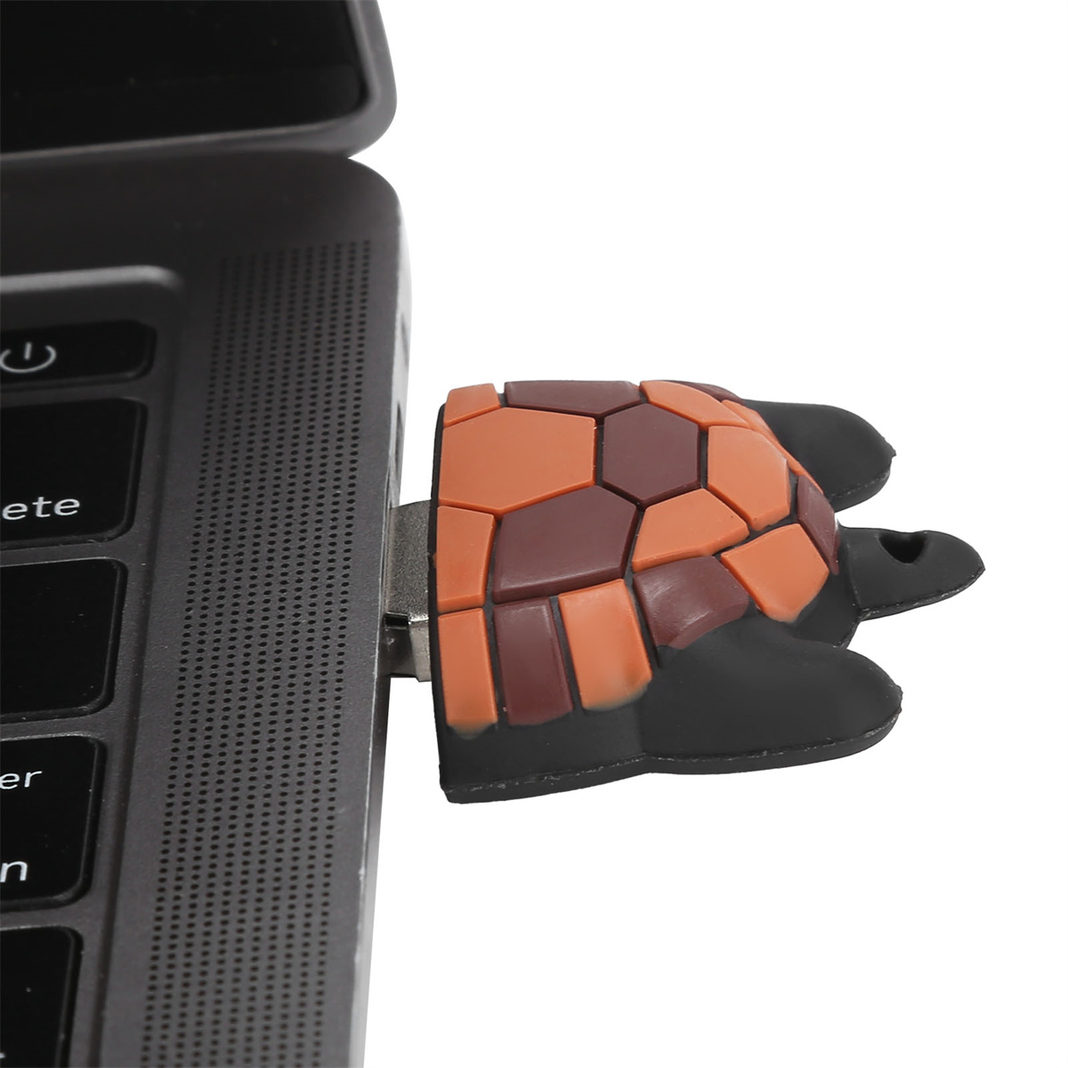 Ein USB-Stick in einem Laptop, geformt wie eine Schildkröte mit braunem und orangefarbenem Panzer.