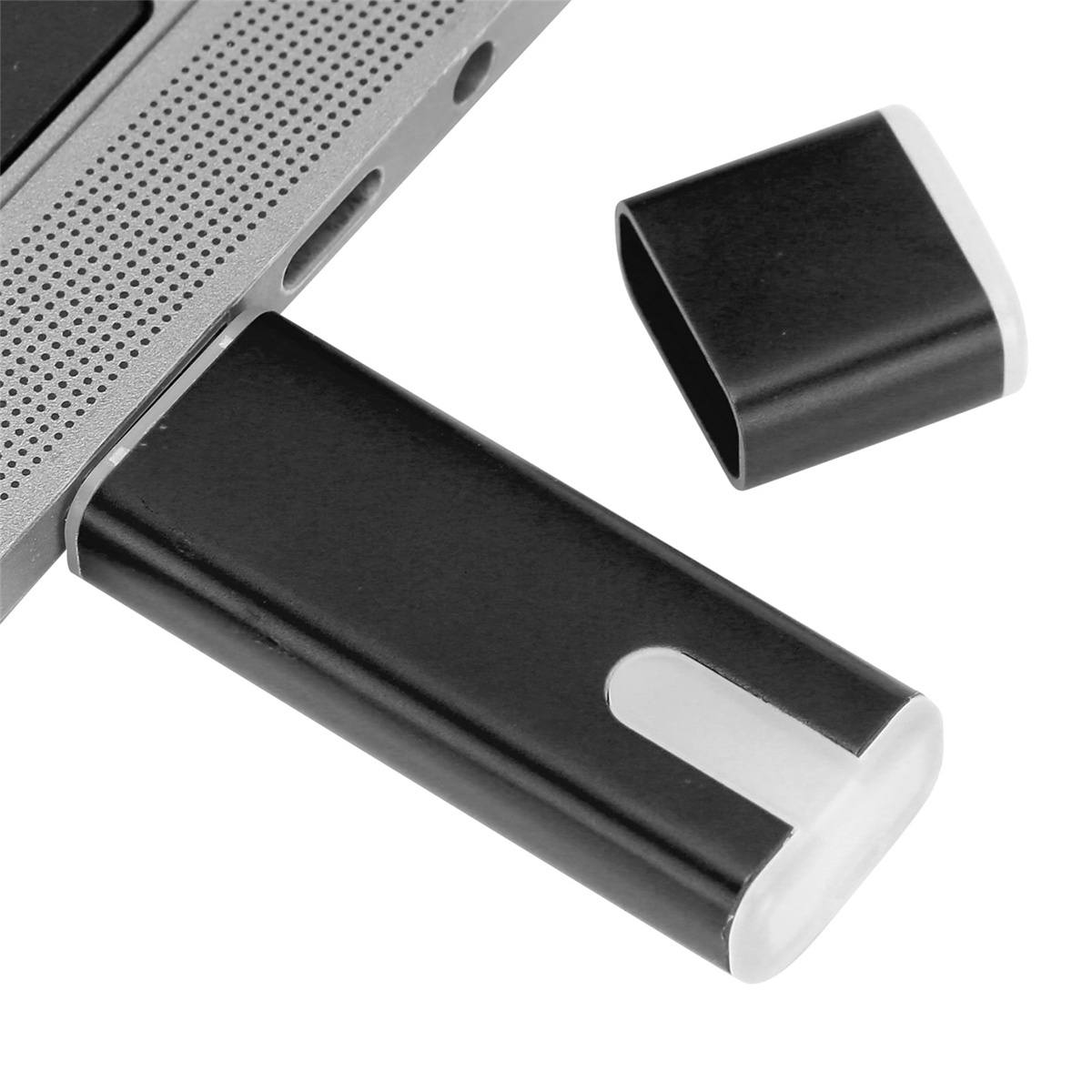 Schwarzer USB-Stick in Laptop eingesetzt. Der Stick ist schwarz und hat ein weißes Ende. Der Laptop ist silber.