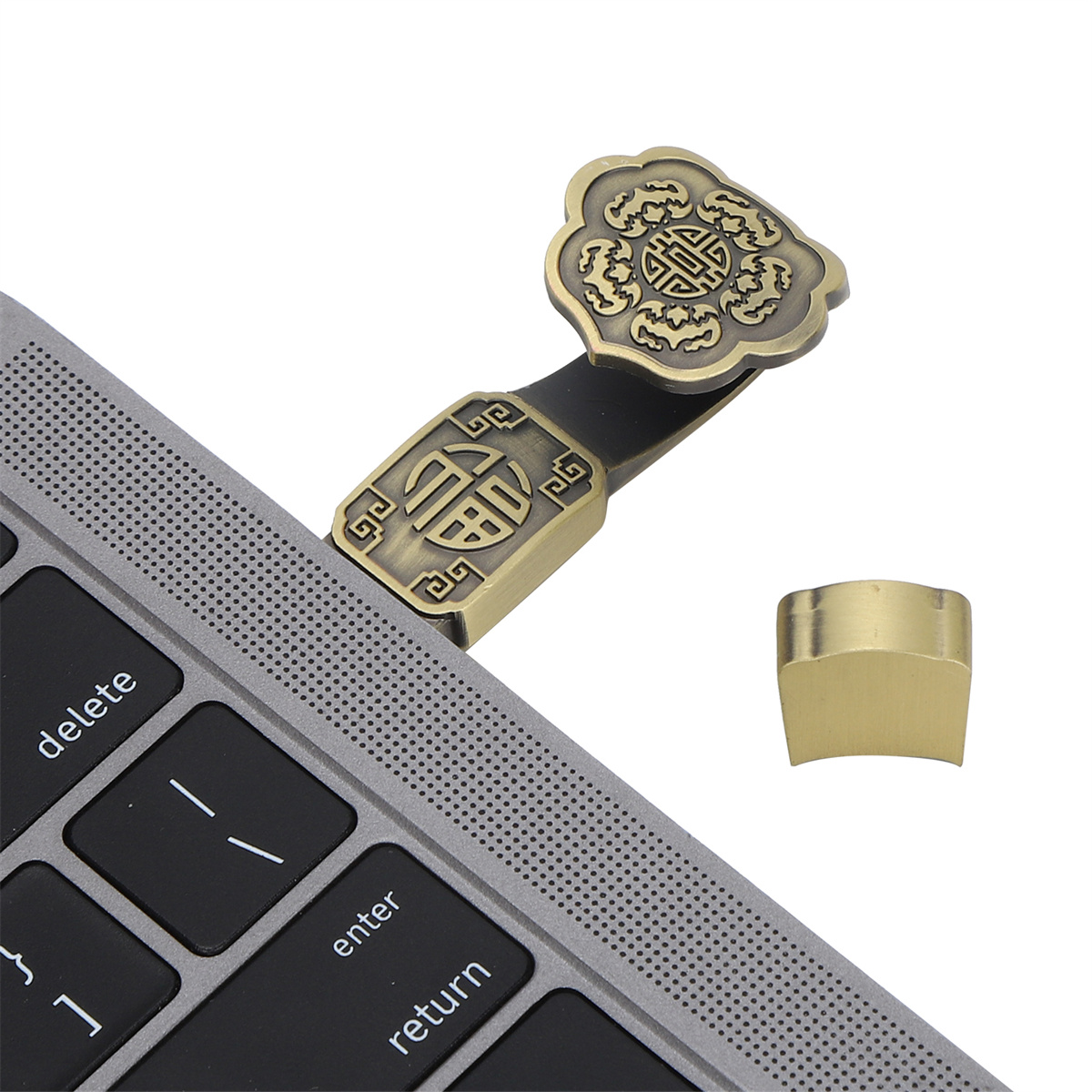Laptop mit einem goldfarbenen Metallverschluss. Der Verschluss ist mit einem verzierten Design geformt.