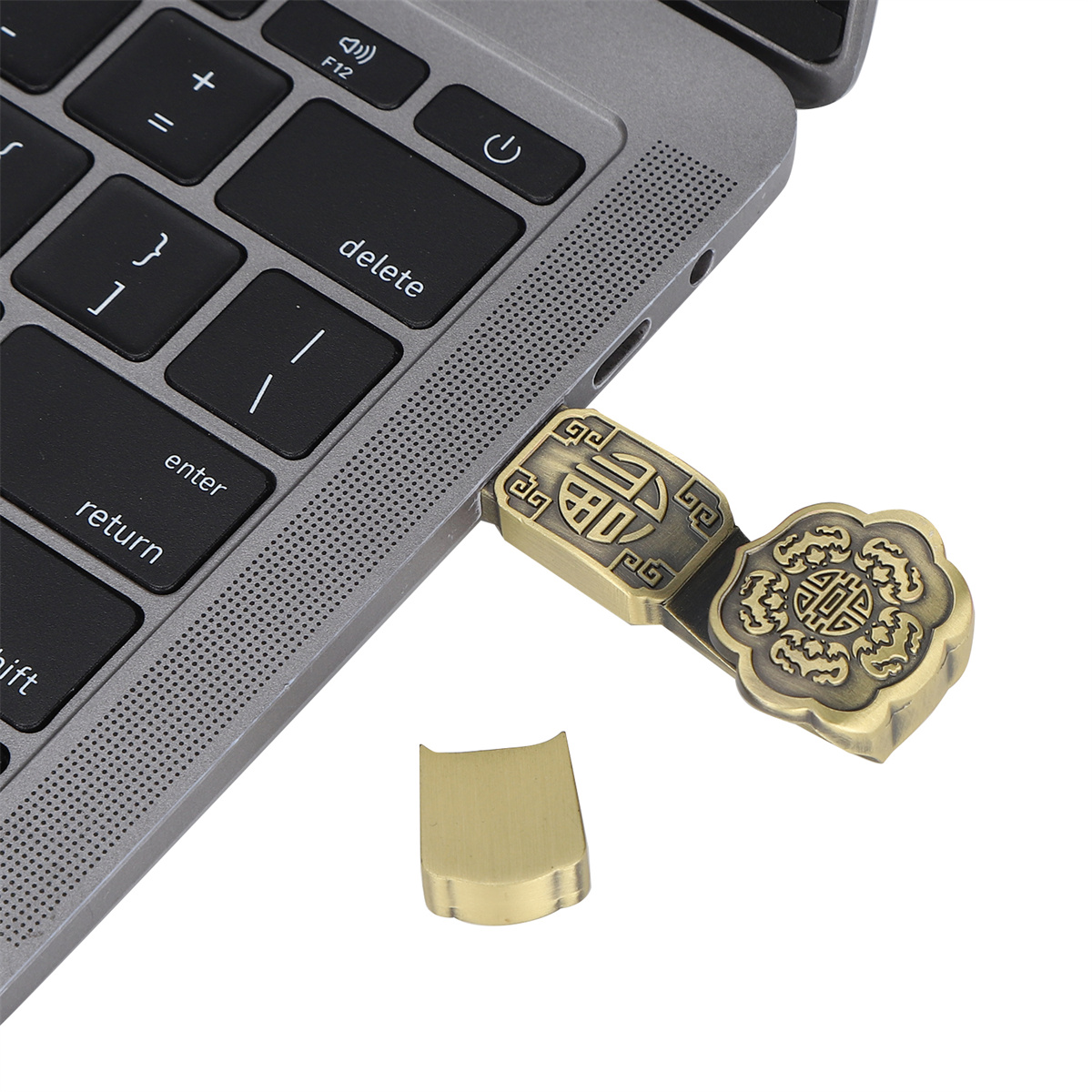 Ein goldfarbener USB-Stick, der in einen Laptop eingesteckt ist, mit einem abgetrennten Teil.