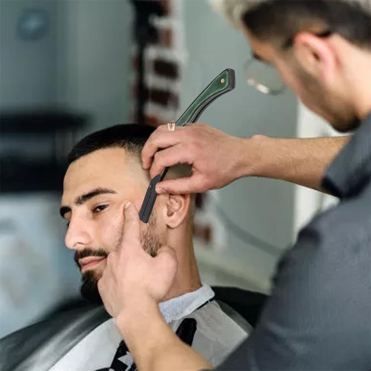 Ein Friseur rasiert die Wange eines Mannes mit einem Rasiermesser. Der Mann sitzt auf einem Stuhl.