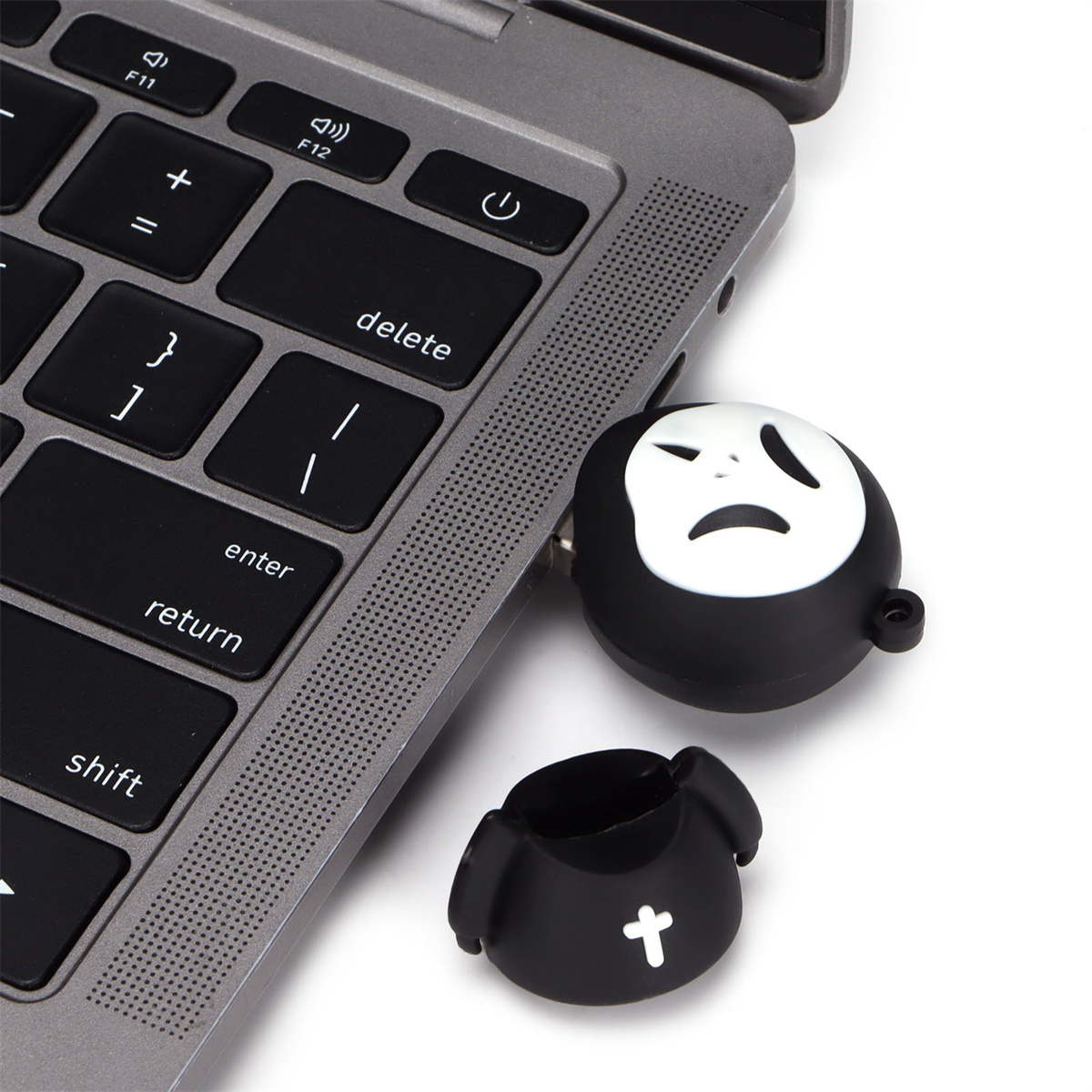 USB-Stick im Laptop. Schwarzer Stick mit traurigem Gesicht, an Laptop-Tastatur angeschlossen.