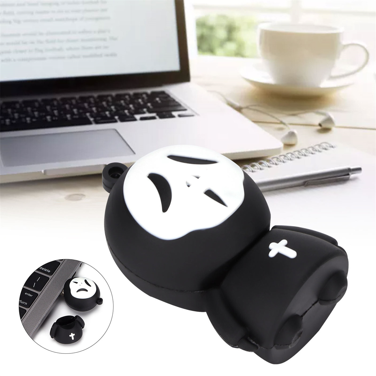 Ein schwarz-weißes USB-Laufwerk des Sensenmanns. Es liegt auf einem Schreibtisch in der Nähe eines Laptops und Zubehör.