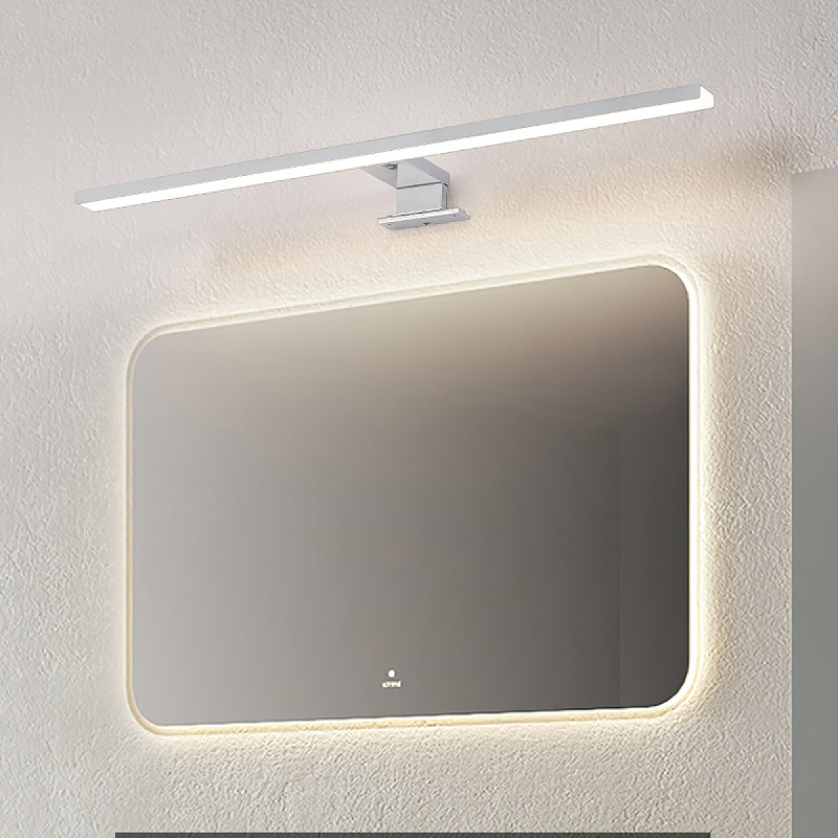 Ein rechteckiger Spiegel mit Licht darüber. Der Spiegel befindet sich in einem modernen Badezimmer. Der Hintergrund ist eine weiße Wand.