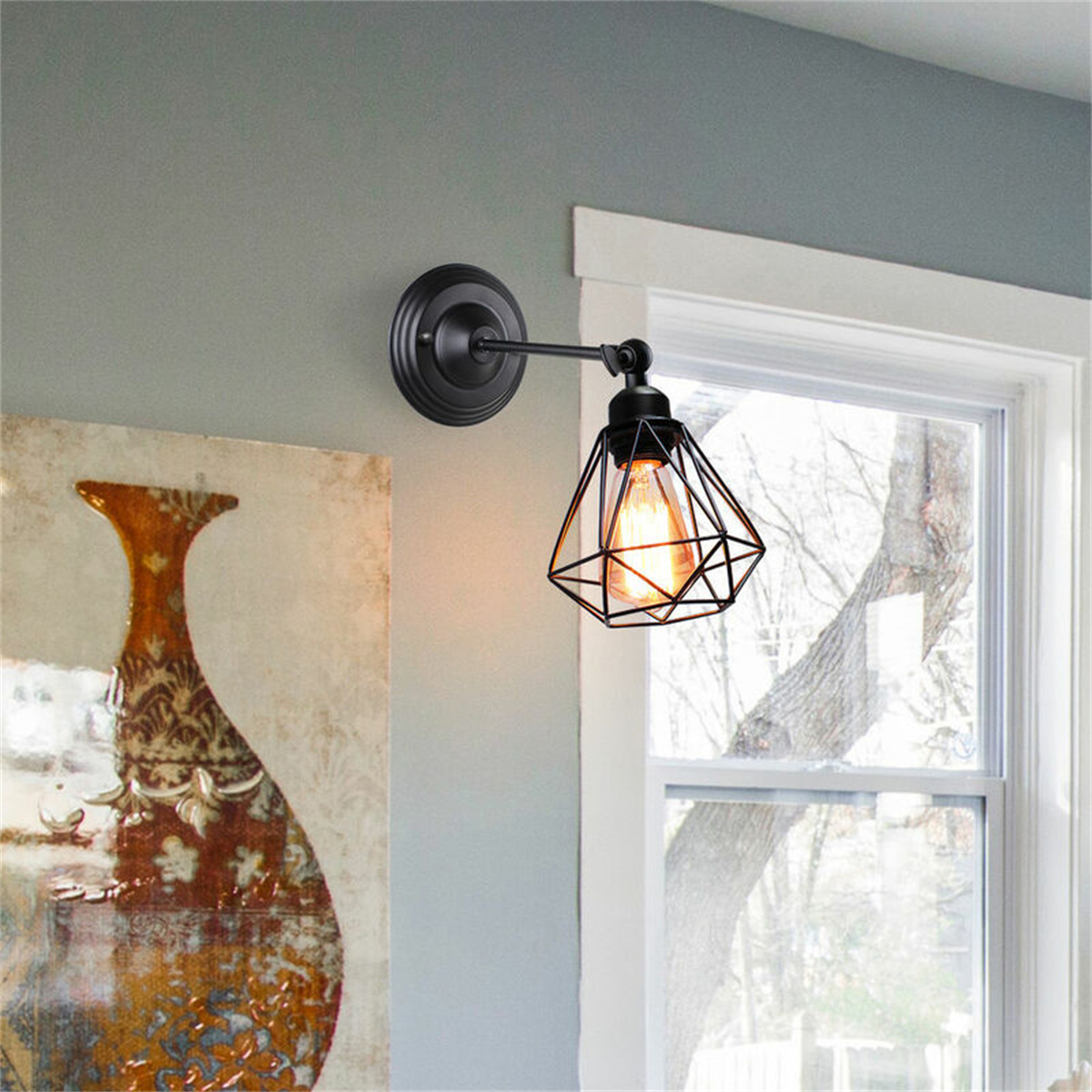 Schwarze geometrische Wandlampe mit Glühbirne. An einer grauen Wand montiert, in der Nähe eines Fensters.