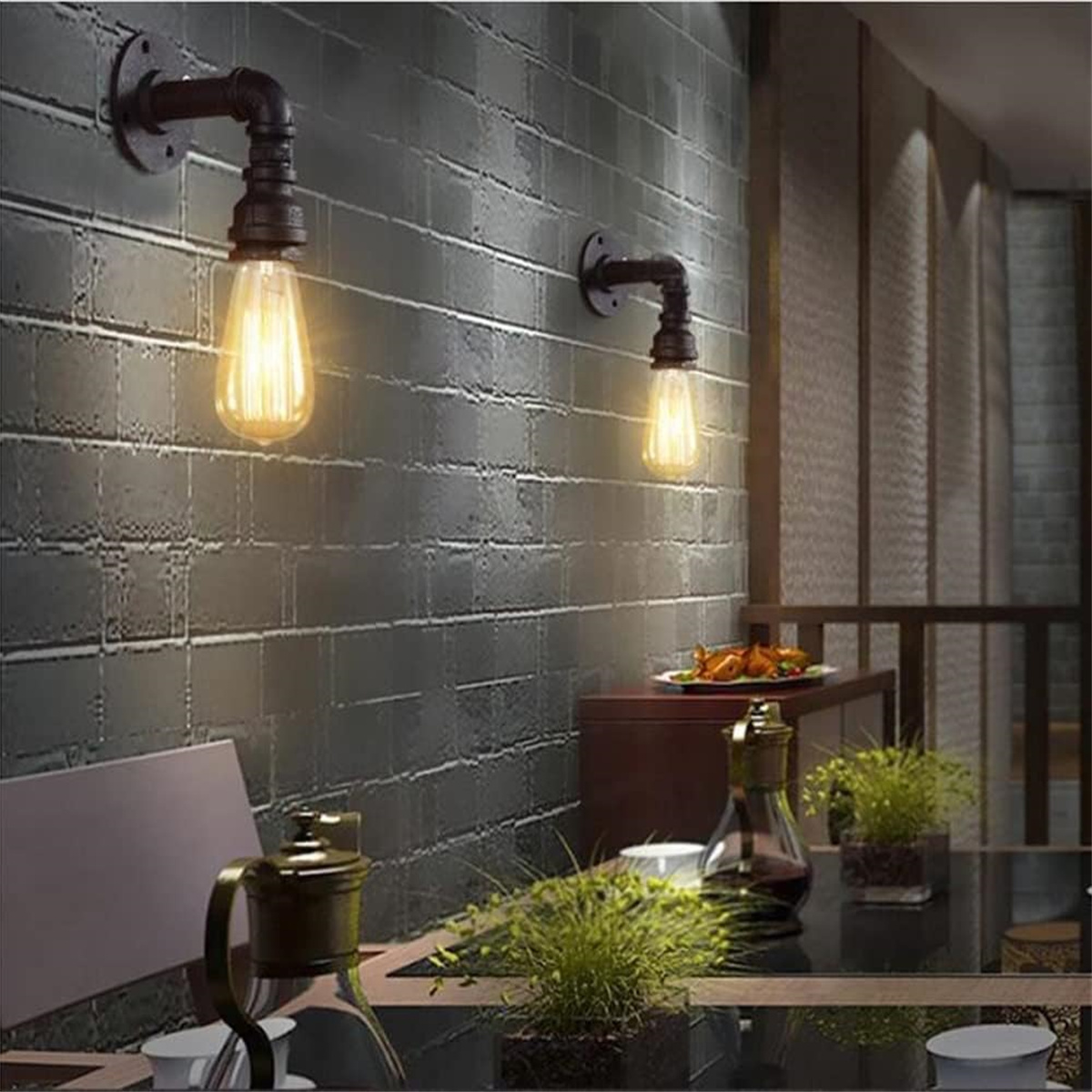 Zwei Wandleuchten mit Edison-Gl ühbirnen, mit dunklem Hintergrund und Pflanzen.