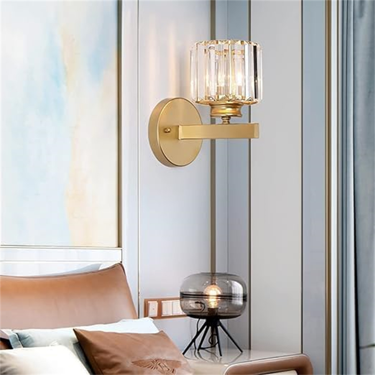 Eine goldene Wandleuchte mit Kristallschirm und eine schwarze Tischleuchte.