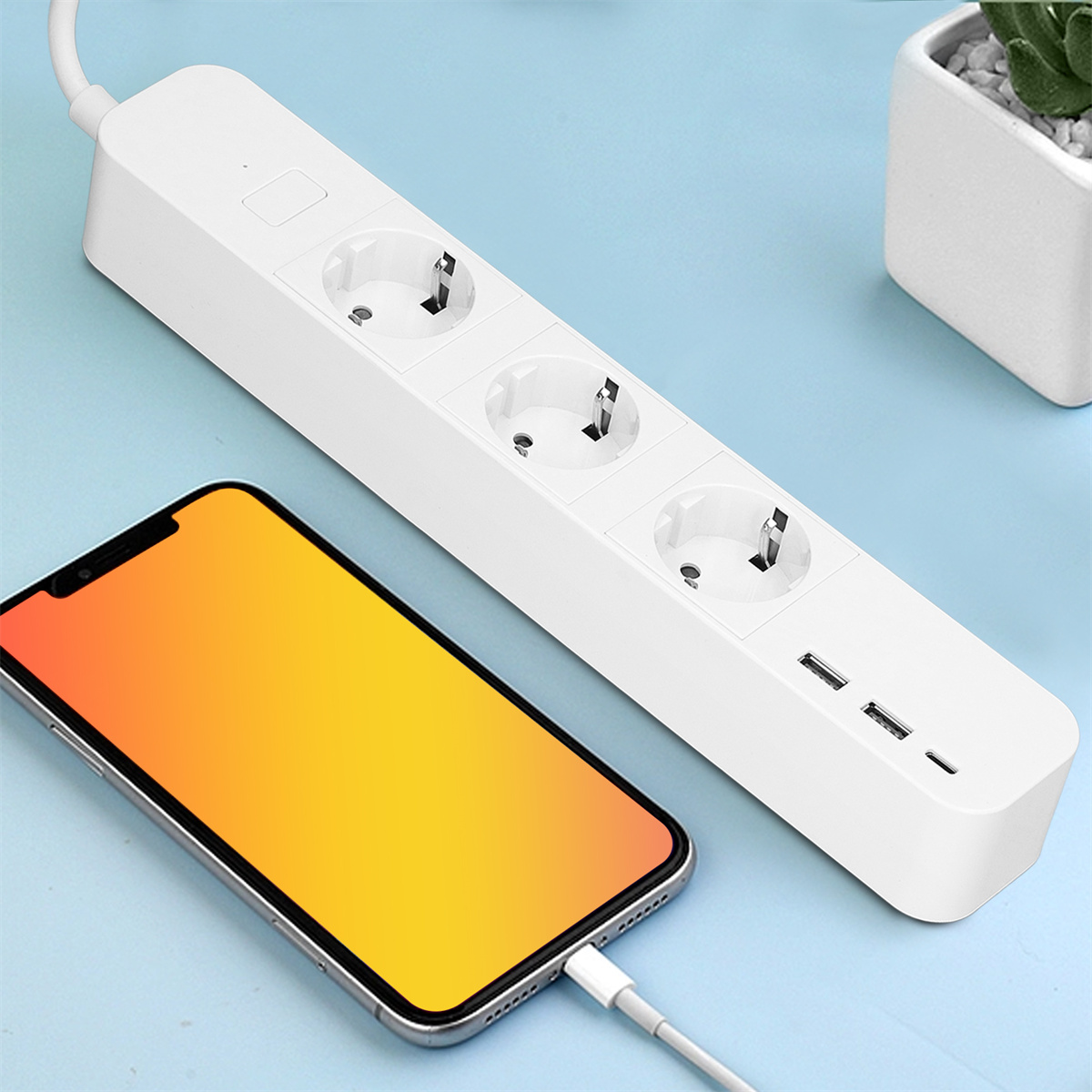Weißes Verlängerungskabel mit drei Steckdosen und zwei USB-Anschlüssen. Telefon lädt.