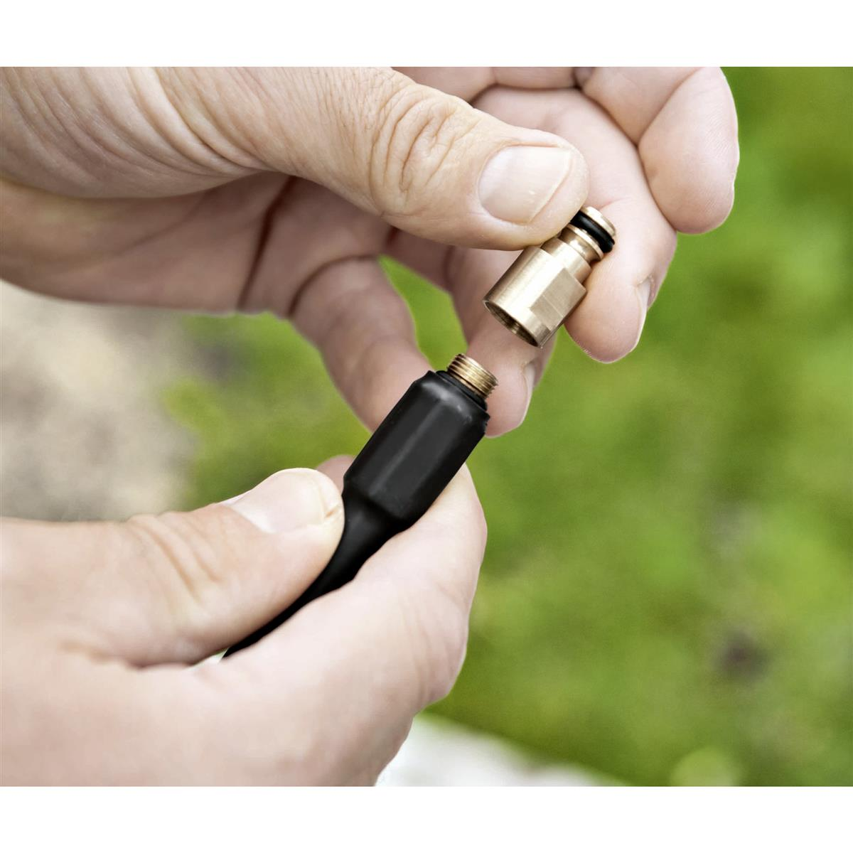 Ręce łączą czarny kabel z mosiężnym złączem z czarnym gumowym pierścieniem.