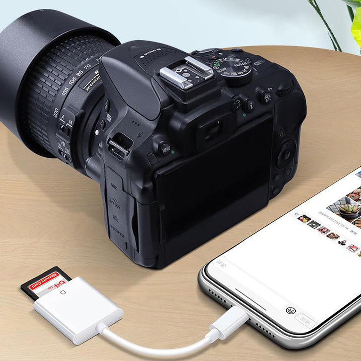 Eine Kamera mit Objektiv ist mit einem Telefon mit SD-Kartenleser verbunden.