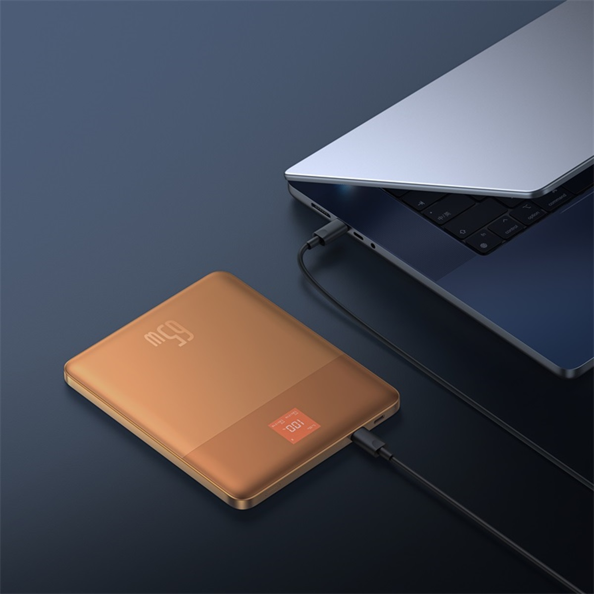 Power bank dorato collegato a un laptop con un cavo di ricarica nero.