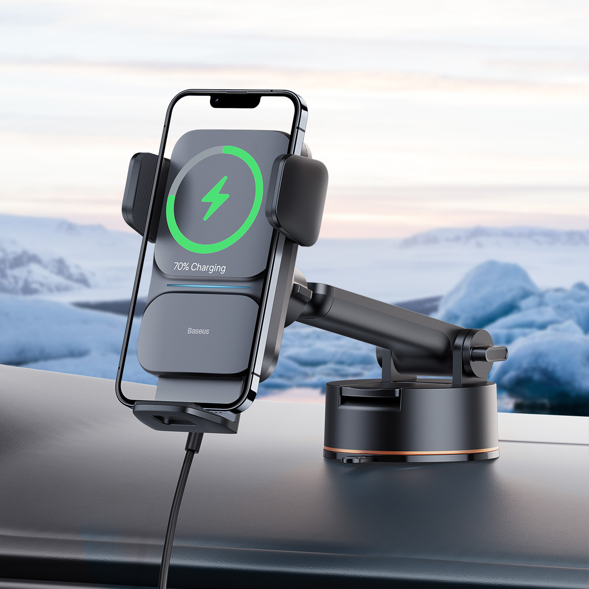 Supporto per telefono nero in auto, con telefono in carica al 70%. Sfondo montuoso innevato.