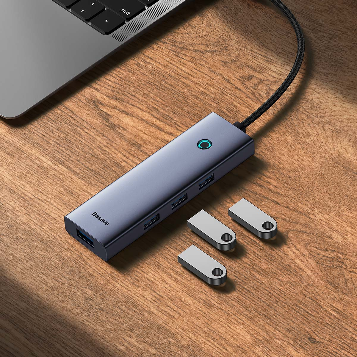 Grijze Baseus hub met USB-poorten, USB-C poort en drie zilveren USB-drives.