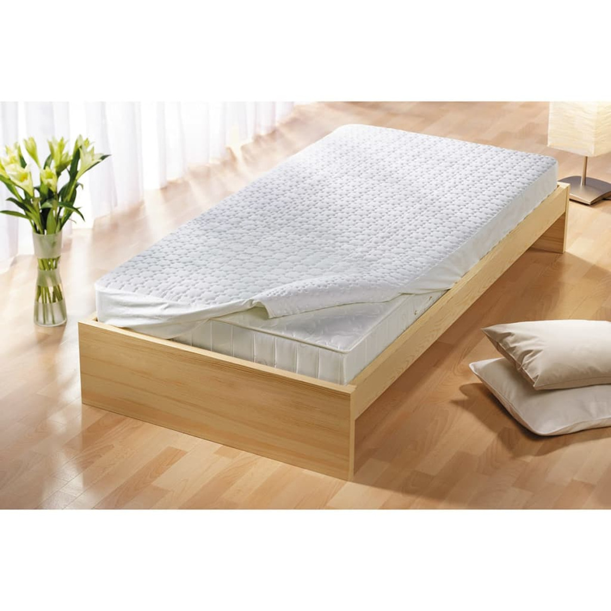 A bed with a white mattress and a wooden frame. Two pillows. Wooden floor. White background.