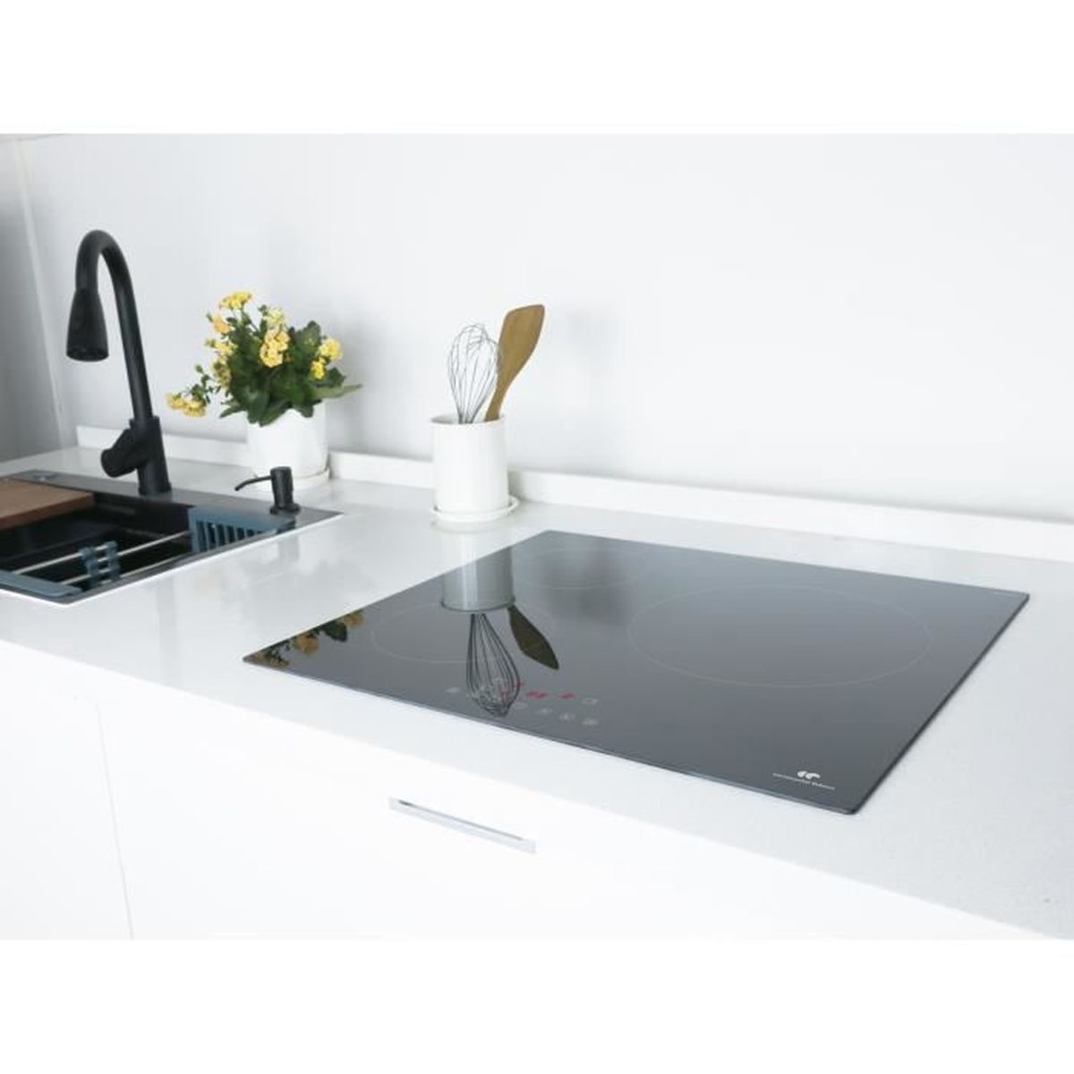 Black glass cooktop on a white countertop. Sink and utensils in the background.