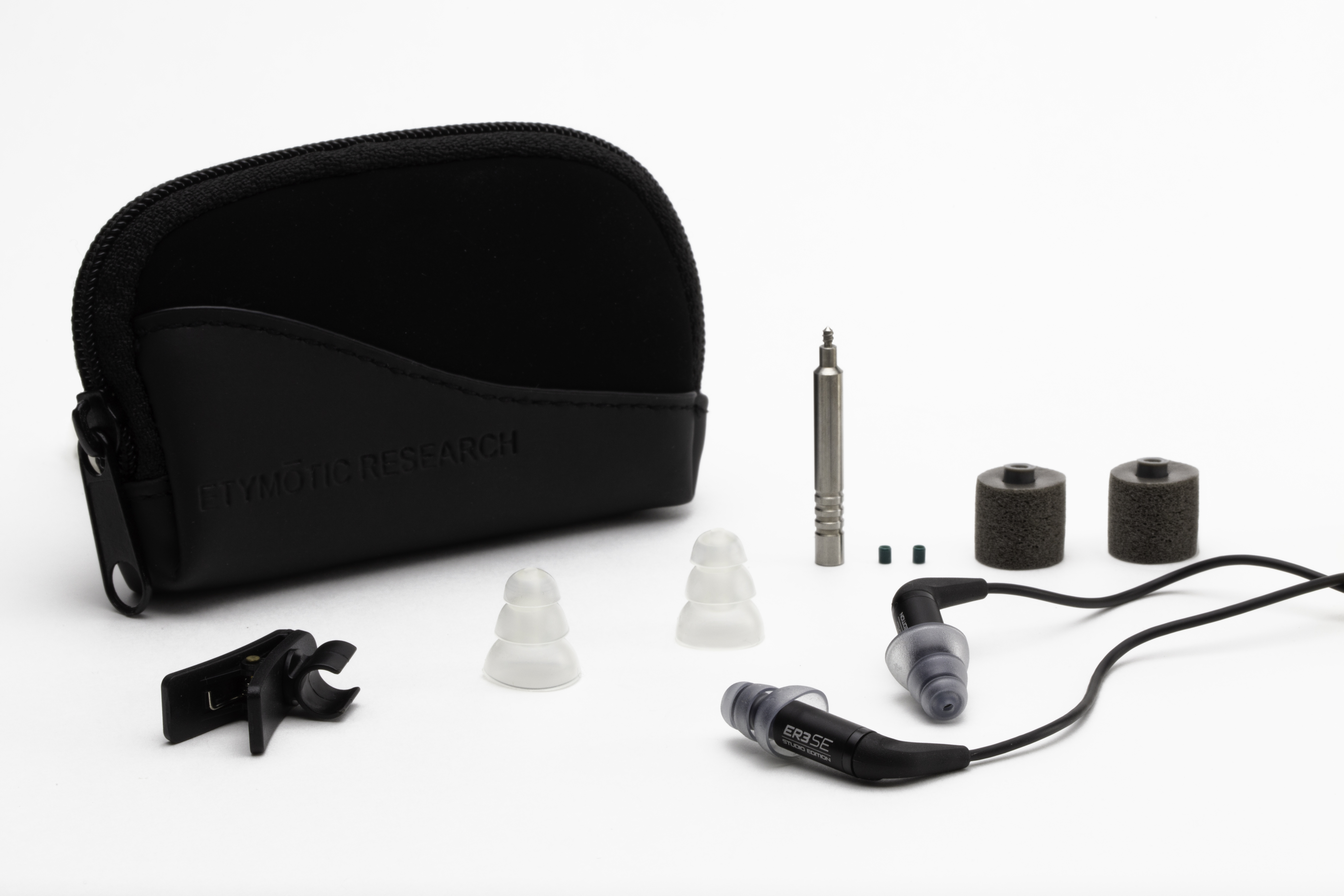 Oortelefoons en accessoires, waaronder een zwarte case, op een witte achtergrond.