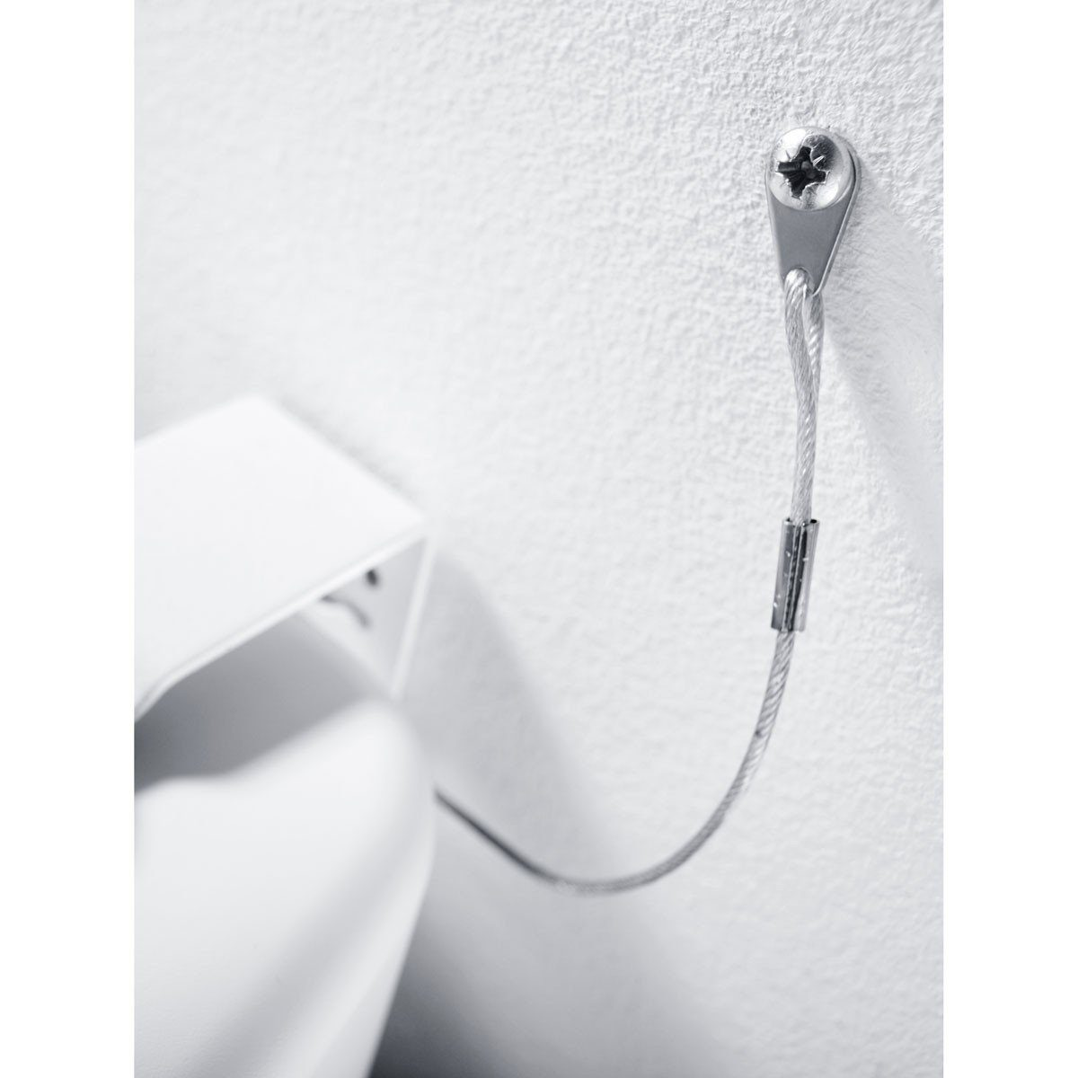 Eine Schraube und ein Kabel, die an einer Wand befestigt sind. Zum Aufhängen von Kunst oder Dekoration.