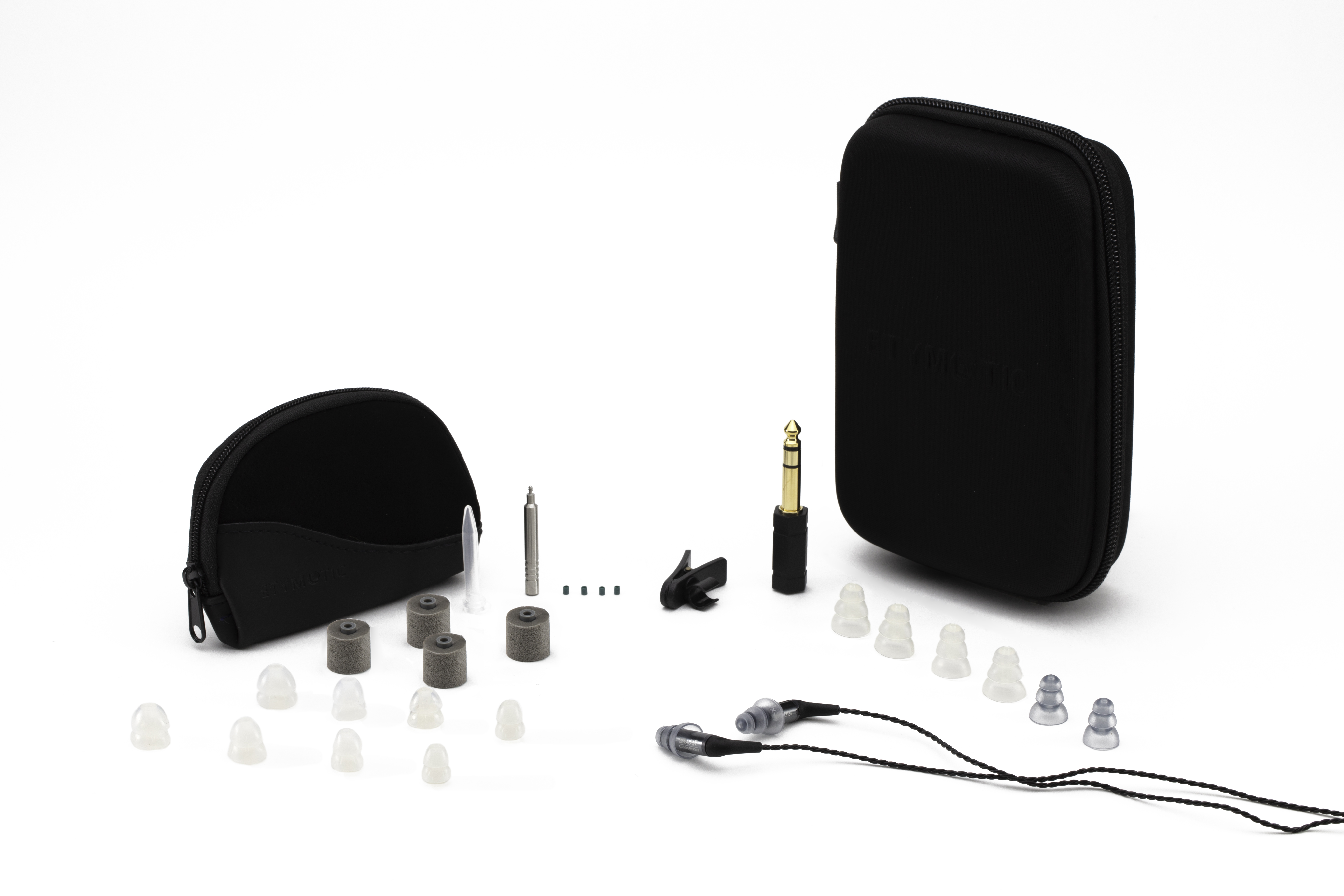 Oortelefoons en accessoires op wit oppervlak. Zwarte case, oordopjes en andere items.