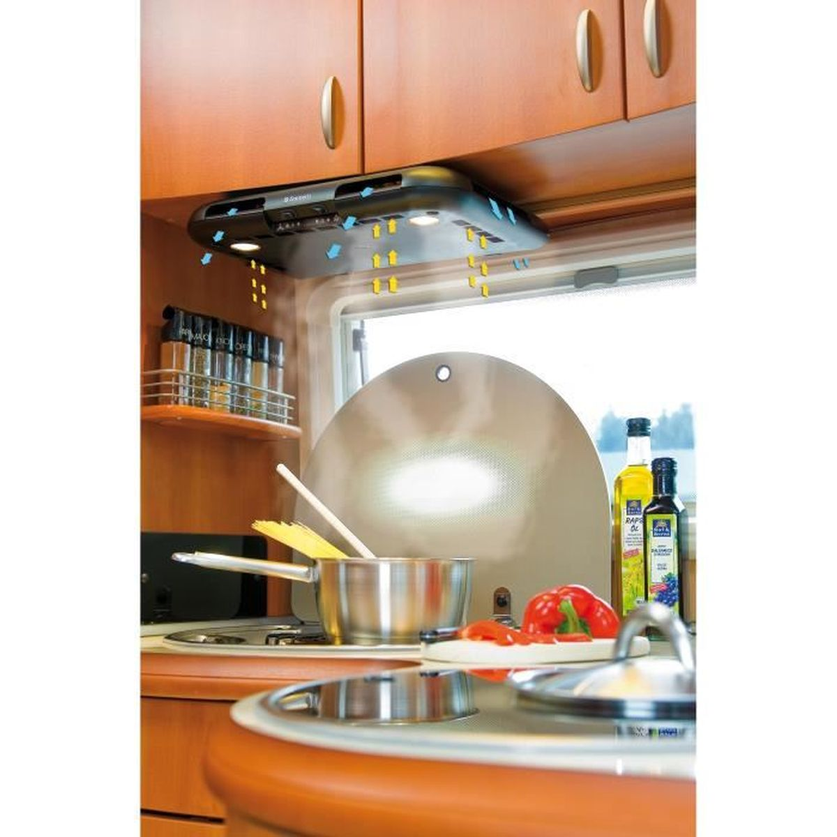 Een keuken in een voertuig, met een afzuigkap, kruiden, keukengerei en voedsel.