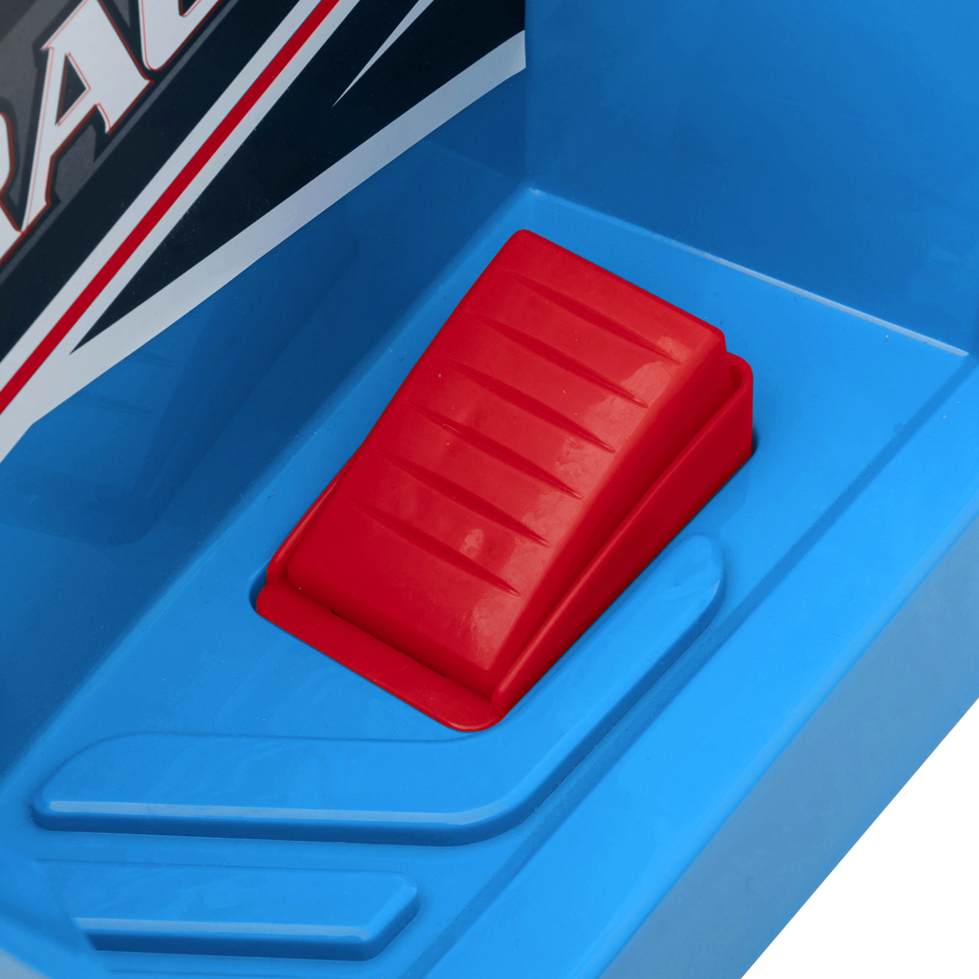 Interno dell'auto giocattolo blu. Il pedale rosso è visibile al centro.