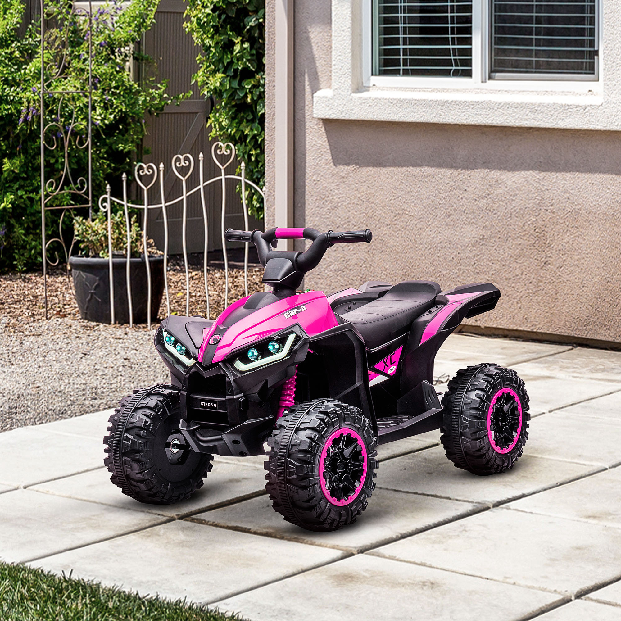 ATV giocattolo rosa e nero su superficie piastrellata. Sfondo: cespugli verdi, muro bianco, finestra.
