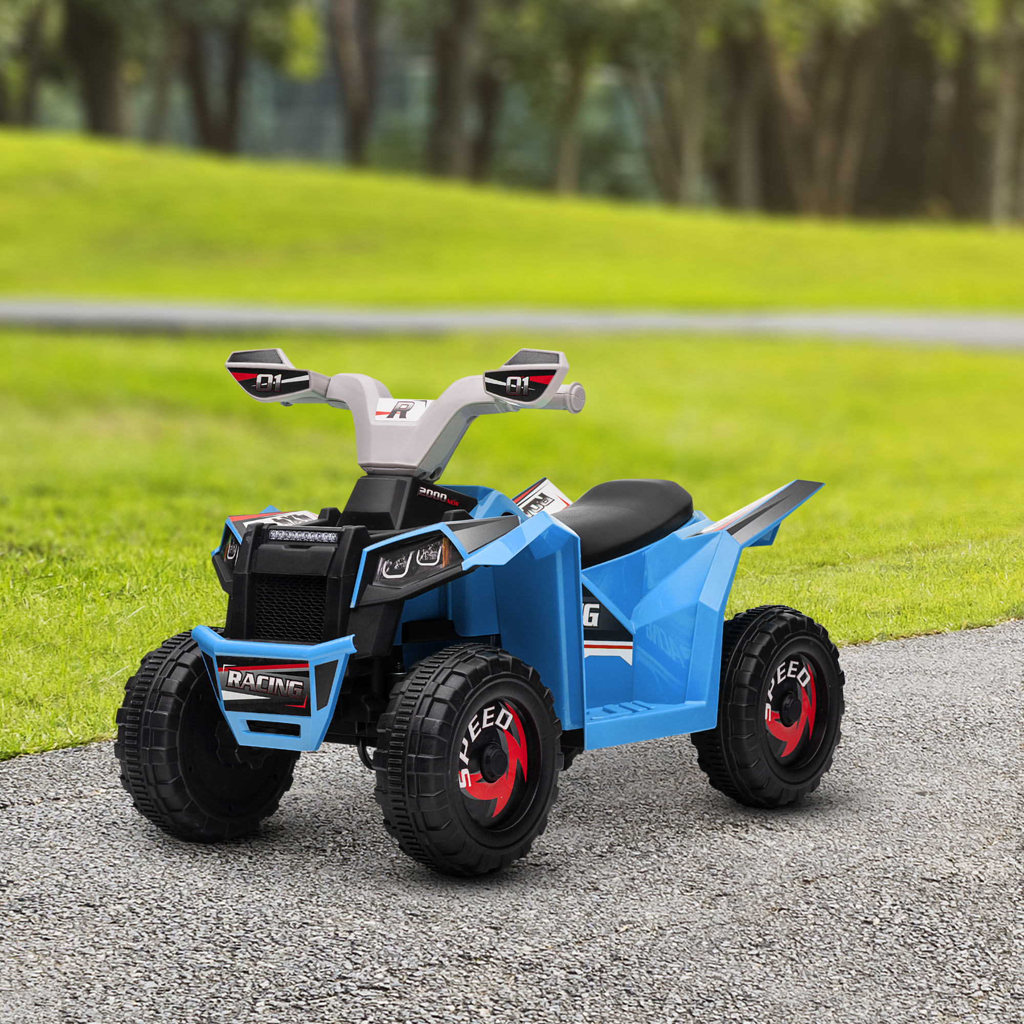 ATV giocattolo blu su un sentiero di ghiaia, con uno sfondo verde di erba e alberi.